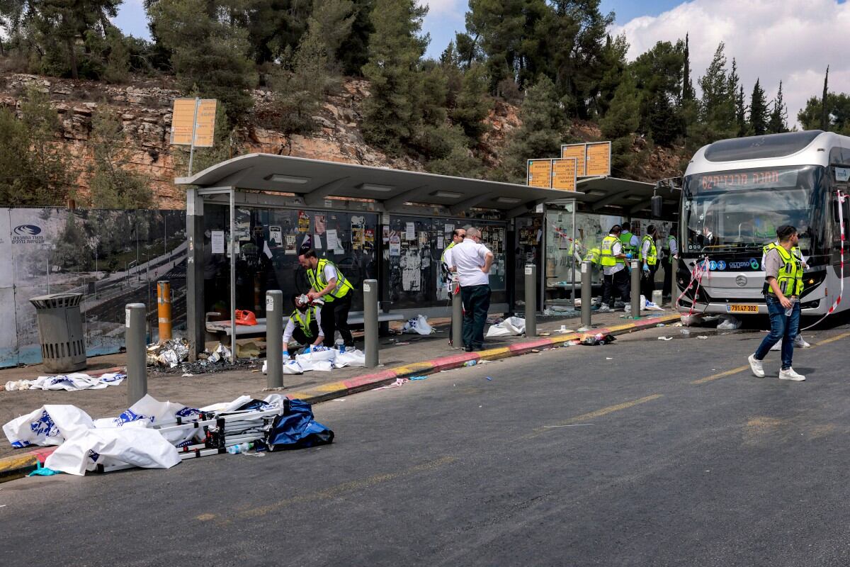 Miembros de la policía recolectan indicios en la parada de autobús.