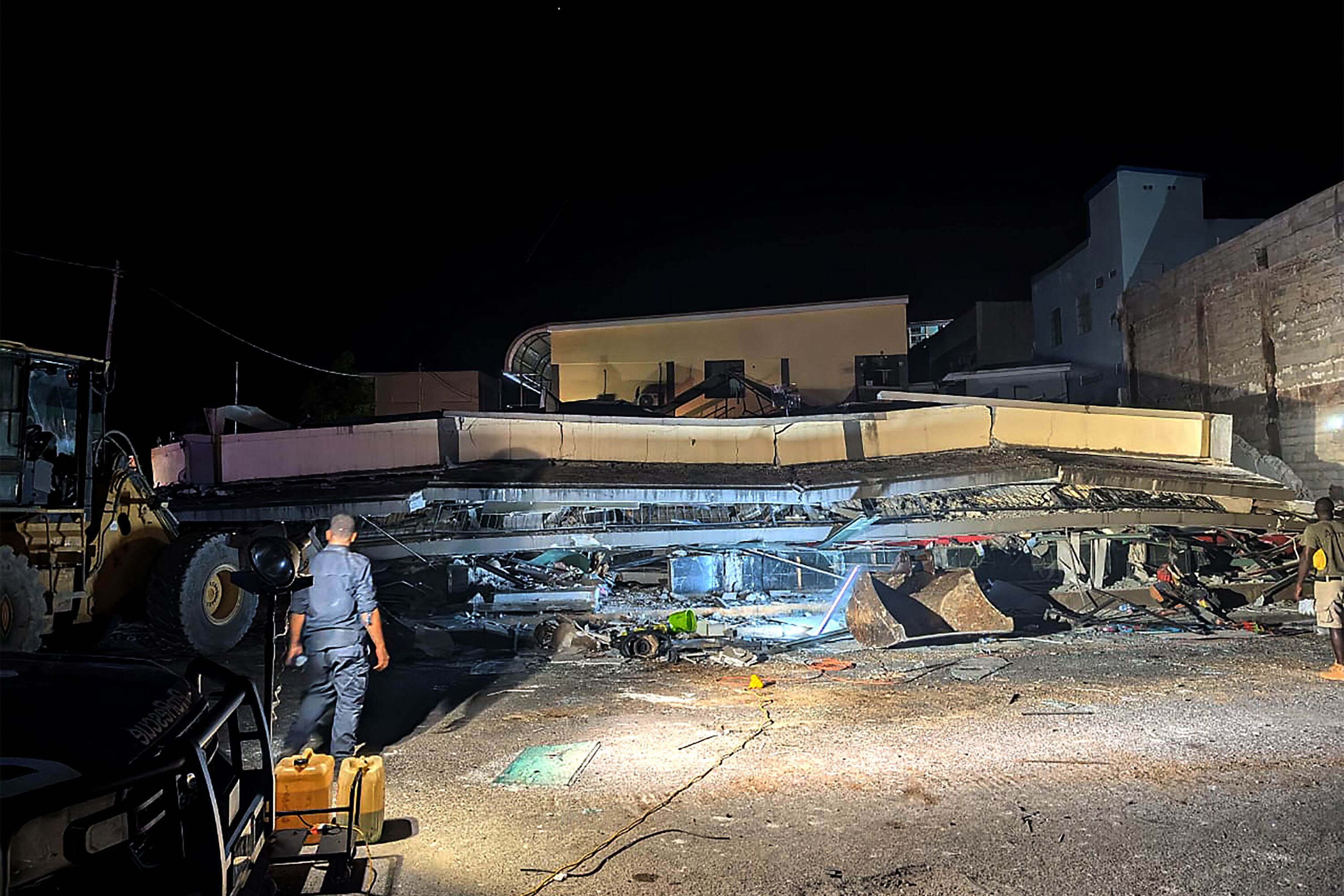 Los equipos de rescate se ven en el lugar de un edificio derrumbado después de que un terremoto sacudiera Port Vila, la capital de Vanuatu.