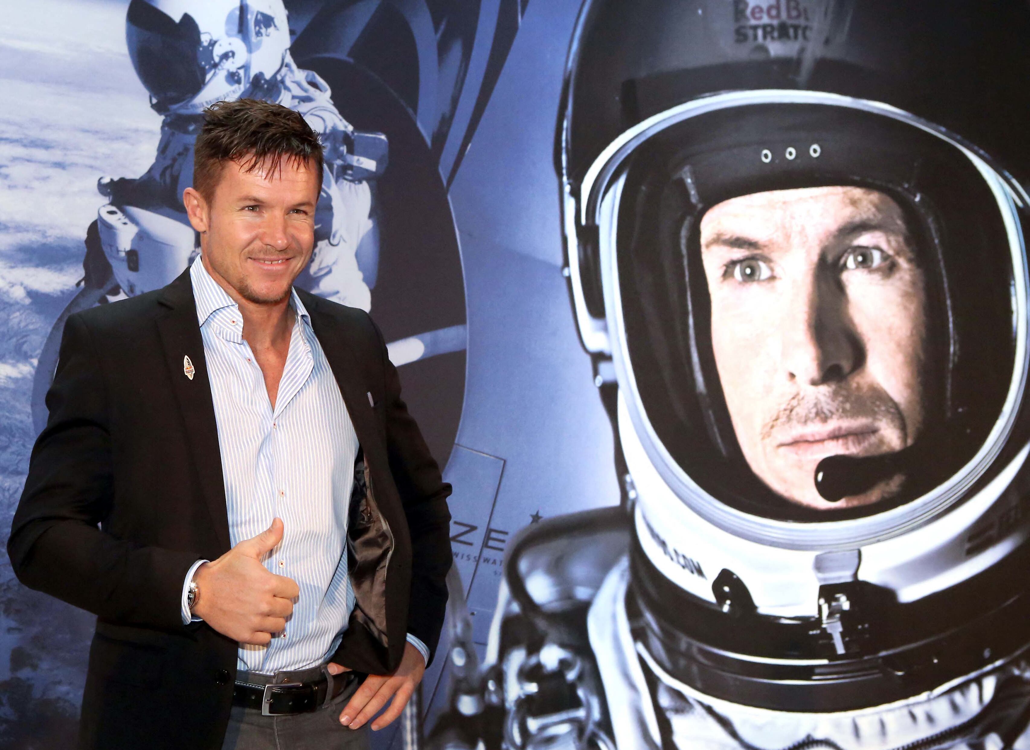 El saltador Felix Baumgartner posa en esta foto del 2013 junto a una imagen de su histórico salto de un año antes.