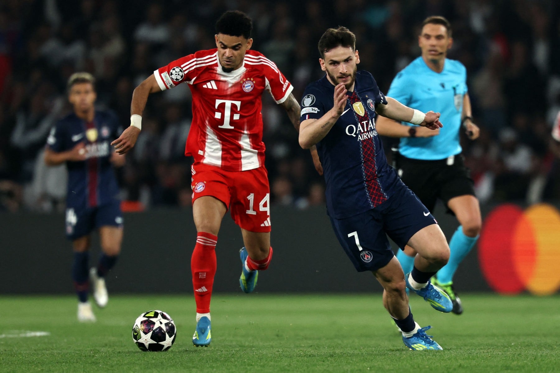 Bayern Munich's Colombian forward Luis Diaz fights for the ball with Paris Saint-Germain's Georgian forward #07 Khvicha Kvaratskhelia during the UEFA Champions League semi-final first leg football match between Paris Saint-Germain (PSG) and Bayern Munich at the Parc des Princes in Paris on April 28, 2026. (Photo by Anne-Christine POUJOULAT / AFP)