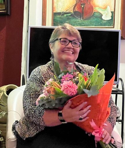 Imagen de la cantante costarricense María Vargas Quirós sonriendo y sosteniendo en sus manos un ramo de flores.