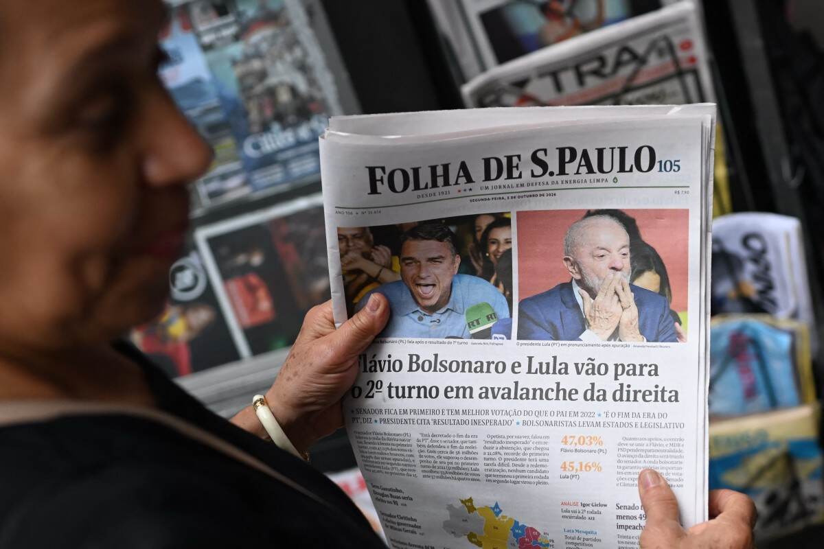 Una mujer sostiene un ejemplar del diario Folha de S. Paulo con información sobre los resultados de las elecciones presidenciales de Brasil, en un puesto de periódicos de São Paulo, Brasil, el 5 de octubre de 2026.