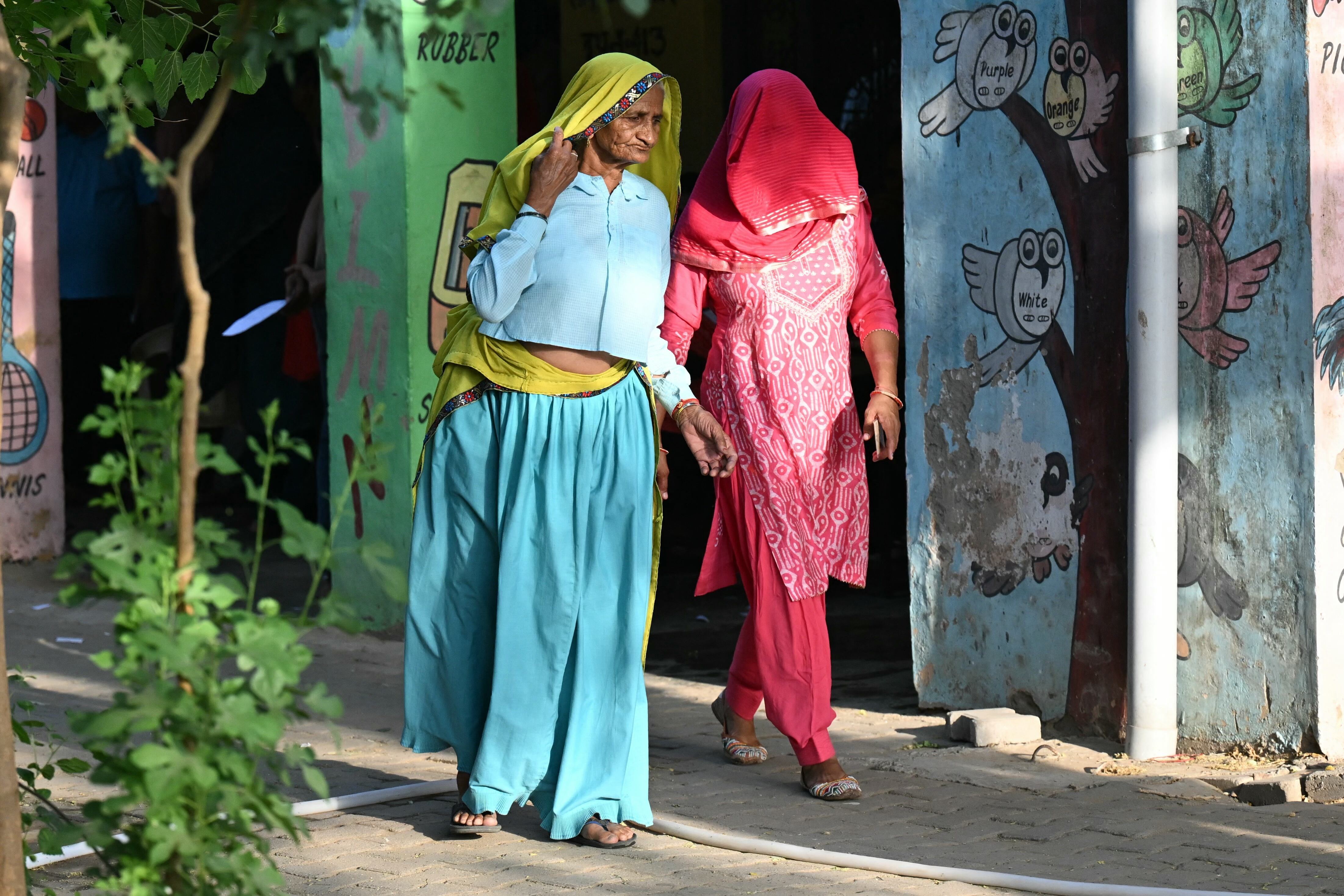 Dos mujeres caminan por la calurosa capital de la India. Nueva Delhi alcanzó casi los 50 grados celcius producto del cambio climático. Foto: AFP