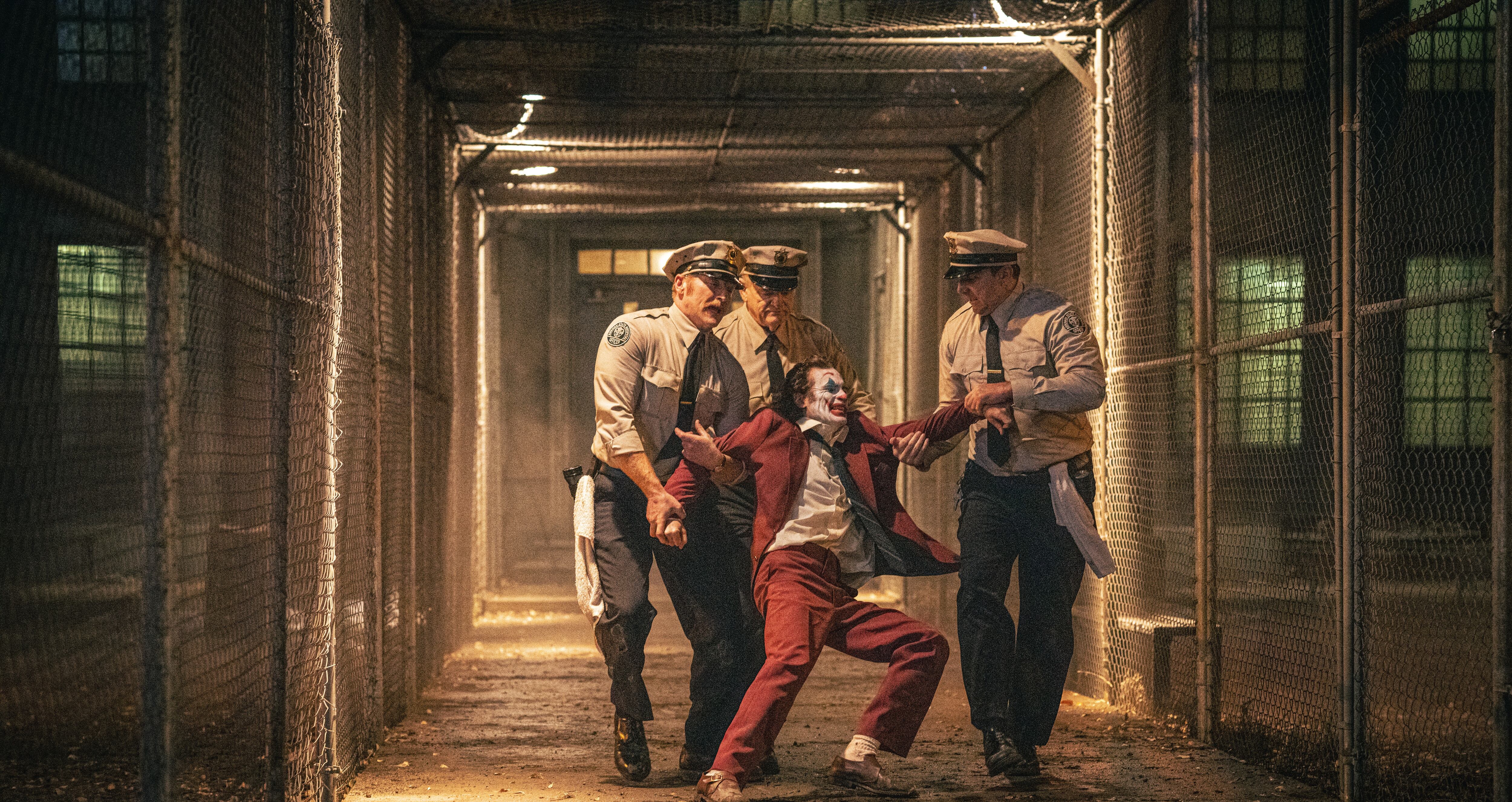Montaje de una imagen de la película 'Joker 2' en la que se ve al Joker ser empujado por policías.