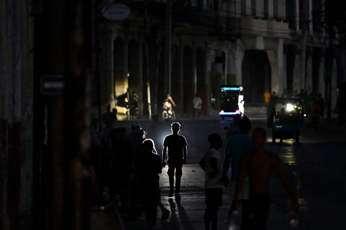 Personas caminan por una calle durante un apagón en La Habana el 13 de mayo de 2026. Cuba culpó a Estados Unidos por la situación “particularmente tensa” de su red eléctrica.