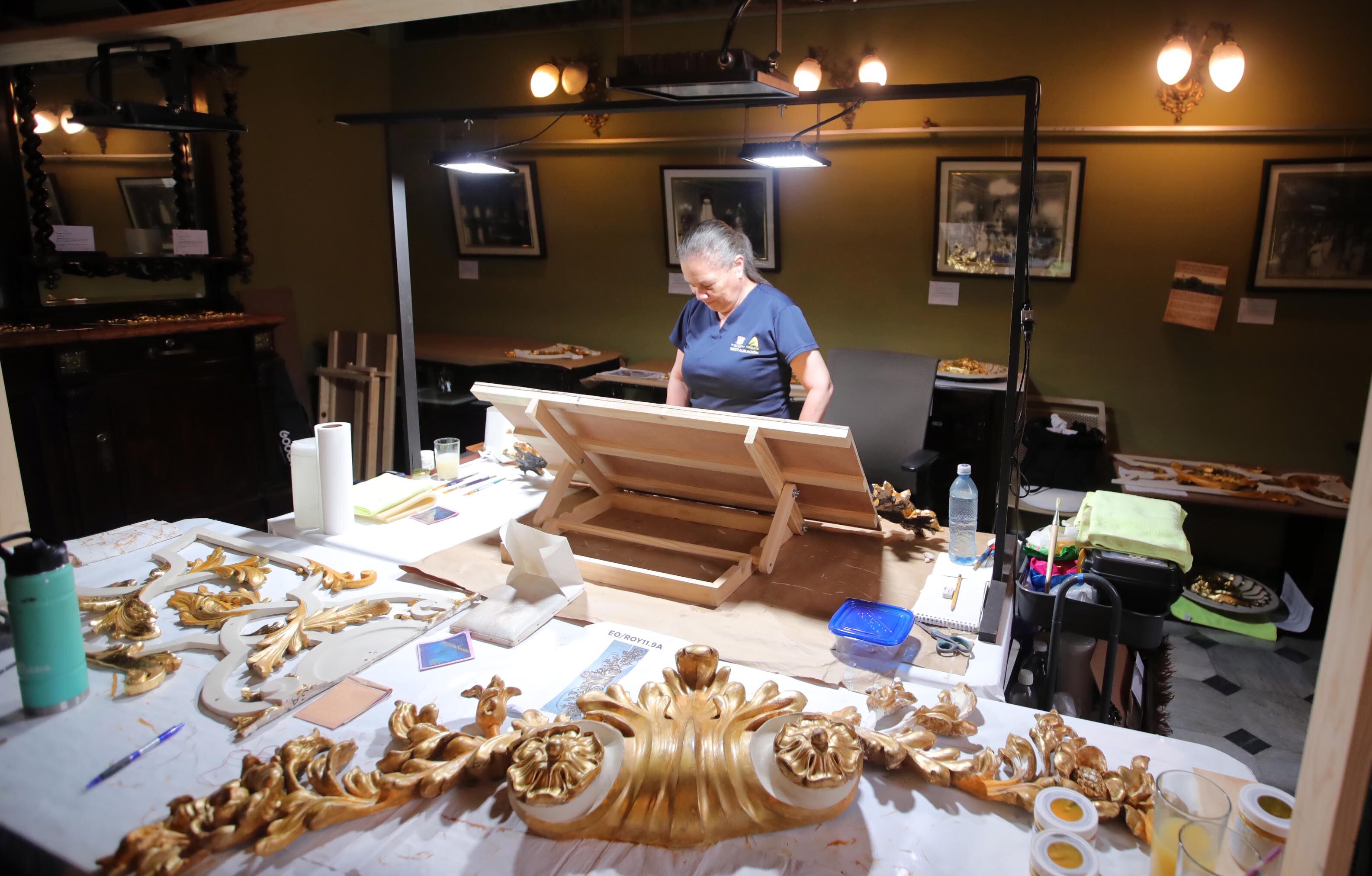 En la imagen se ve a una persona realizando trabajos de conservación y restauración en varias piezas del Teatro Nacional.