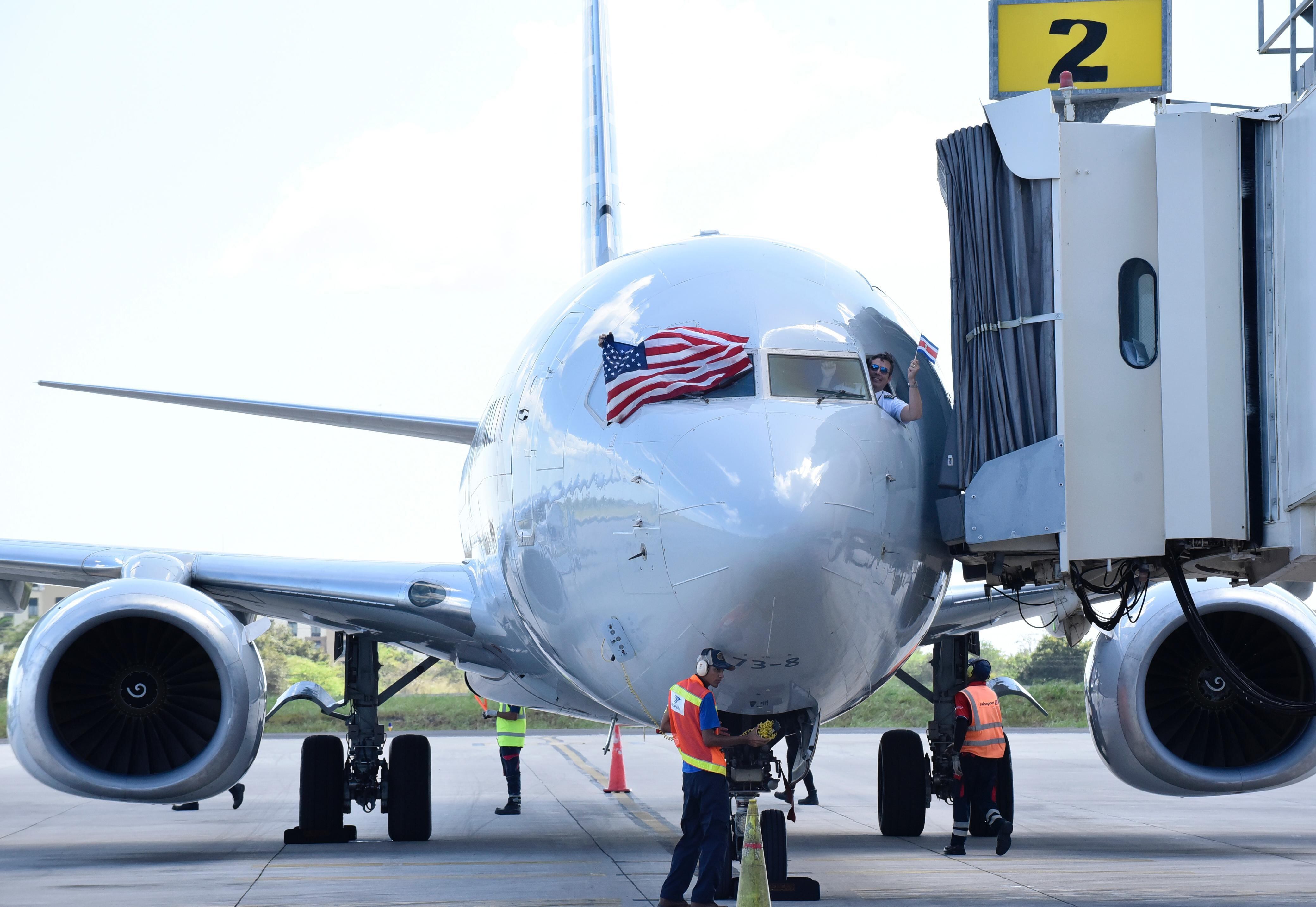 Avión de American Airlines en pista del aeropuerto Daniel Oduber en Liberia, con bandera de Estados Unidos en la ventanilla del piloto