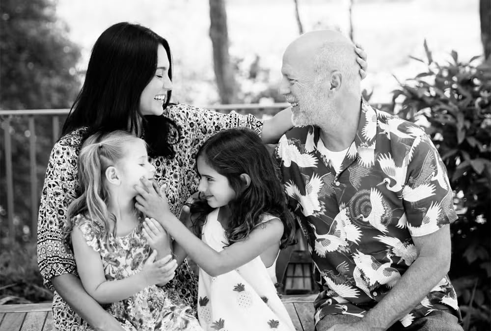 Bruce Willis, su esposa Emma Heming Willis y sus hijas sonríen en una foto familiar. La imagen destaca el amor y la unión de la familia mientras el actor enfrenta la demencia frontotemporal.