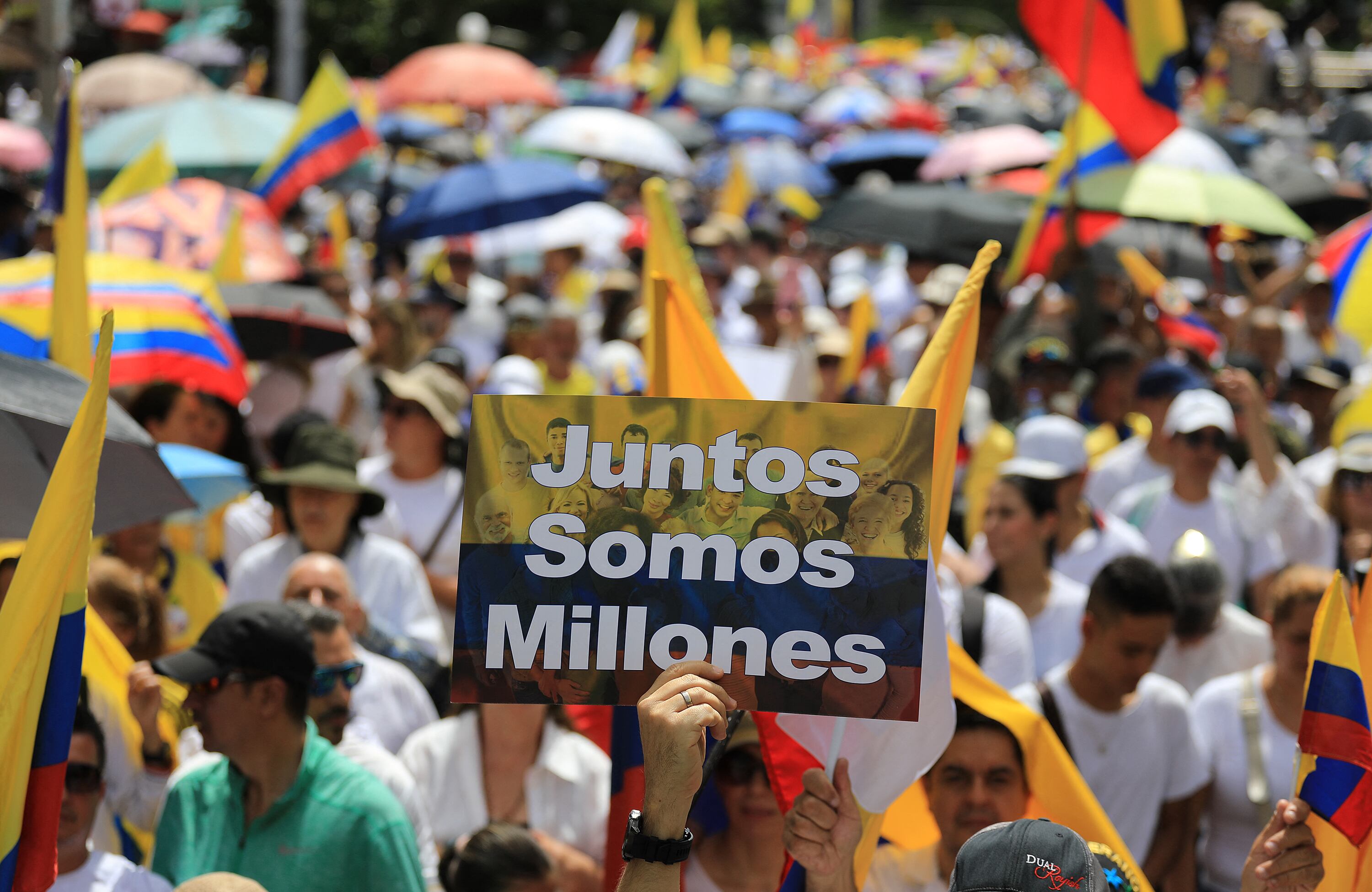 People wearing white t-shirts and holding national flags participate in the so-called "Silent March" to show support for the health of Senator Miguel Uribe Turbay and to call for peace for the country in Medellin, Colombia, on June 15, 2025. Uribe, a 39-year-old conservative senator, was shot twice in the head and once in the leg while giving a speech in a park on June 7 in western Bogota. (Photo by JAIME SALDARRIAGA / AFP)