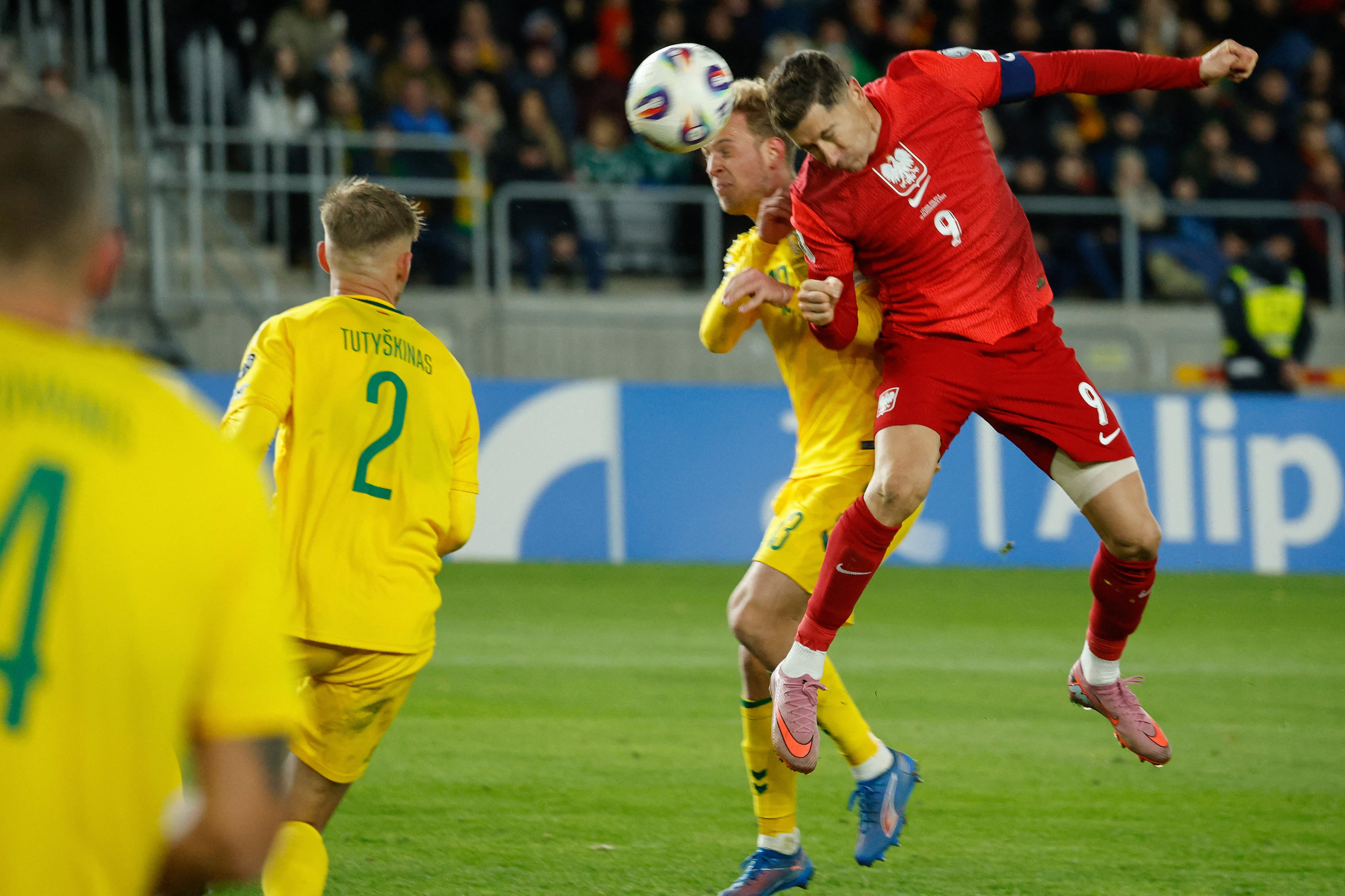 El delantero polaco Robert Lewandowski se impone aquí al defensor lituano Justas Lasickas en el partido por las eliminatorias rumbo al Mundial 2026.