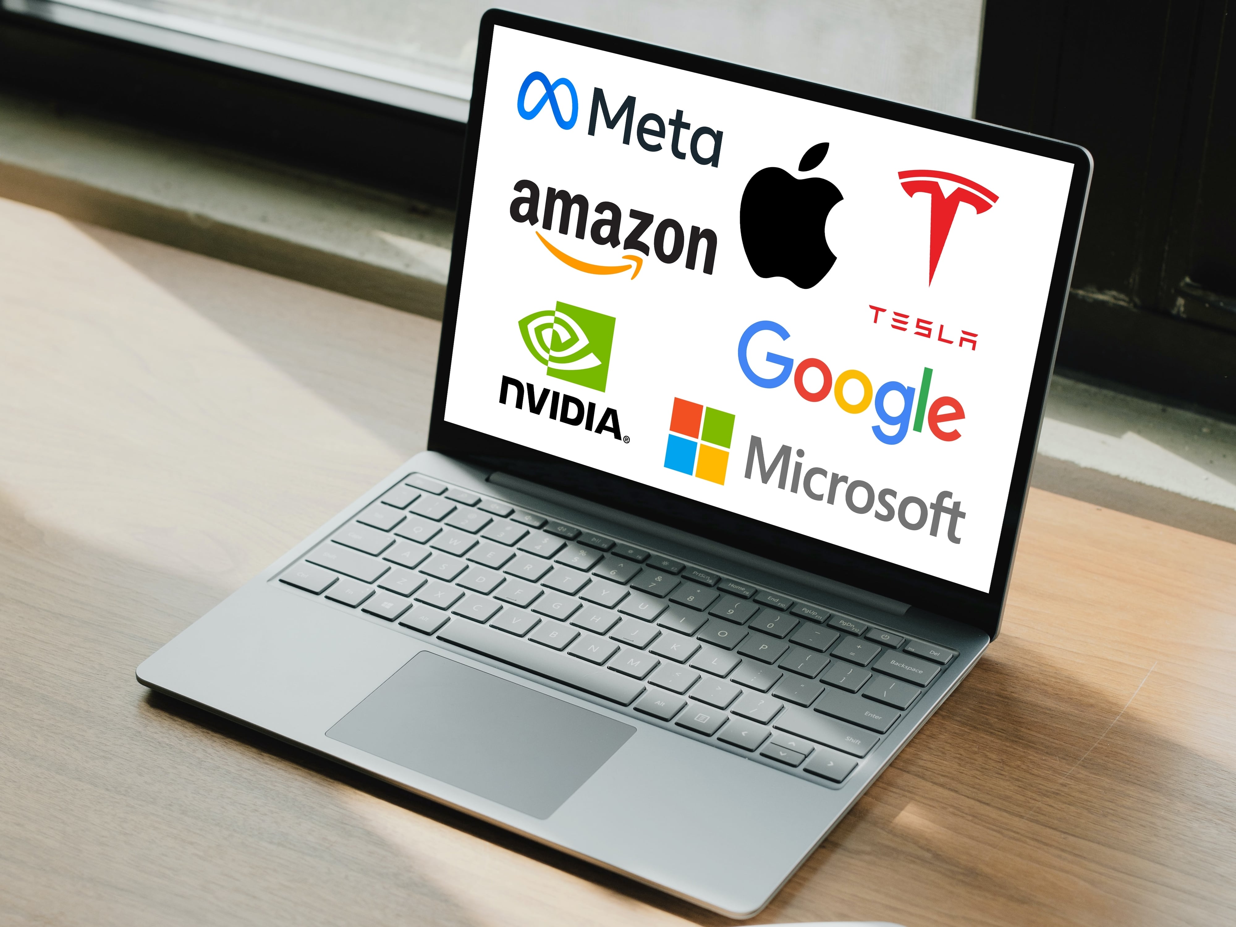 Los Siete Magníficos: logos de las 7 compañías de tecnología más poderosas de Estados Unidos desplegados en pantalla de laptop