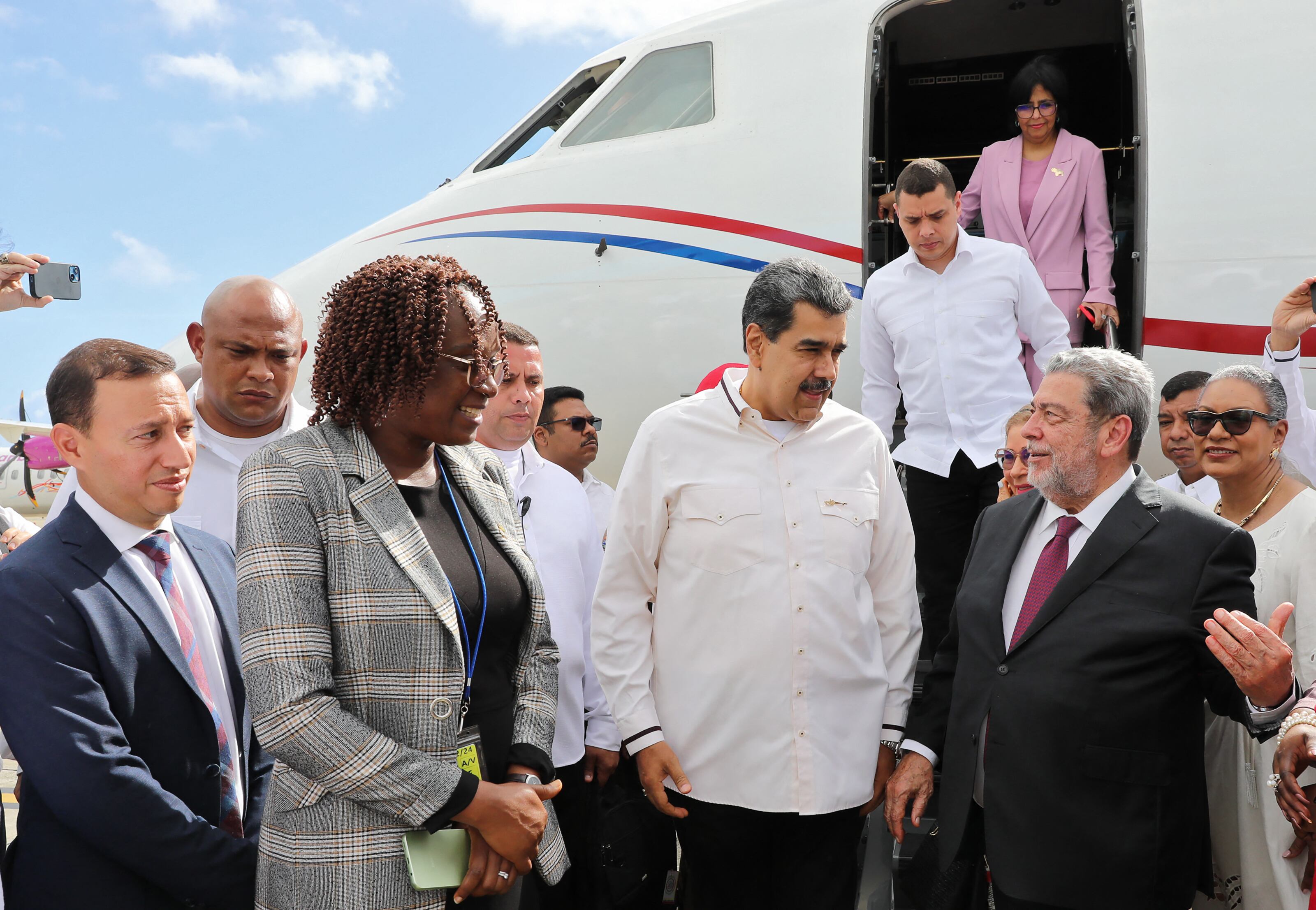 Esta fotografía difundida por la Presidencia venezolana muestra al presidente de Venezuela, Nicolás Maduro (centro), hablando con el primer ministro de San Vicente y las Granadinas, Ralph Everard Gonsalves (derecha), al aterrizar en el Aeropuerto Internacional de Argyle en Argyle, cerca de Kingstown, en San Vicente y las Granadinas el 14 de diciembre de 2023.