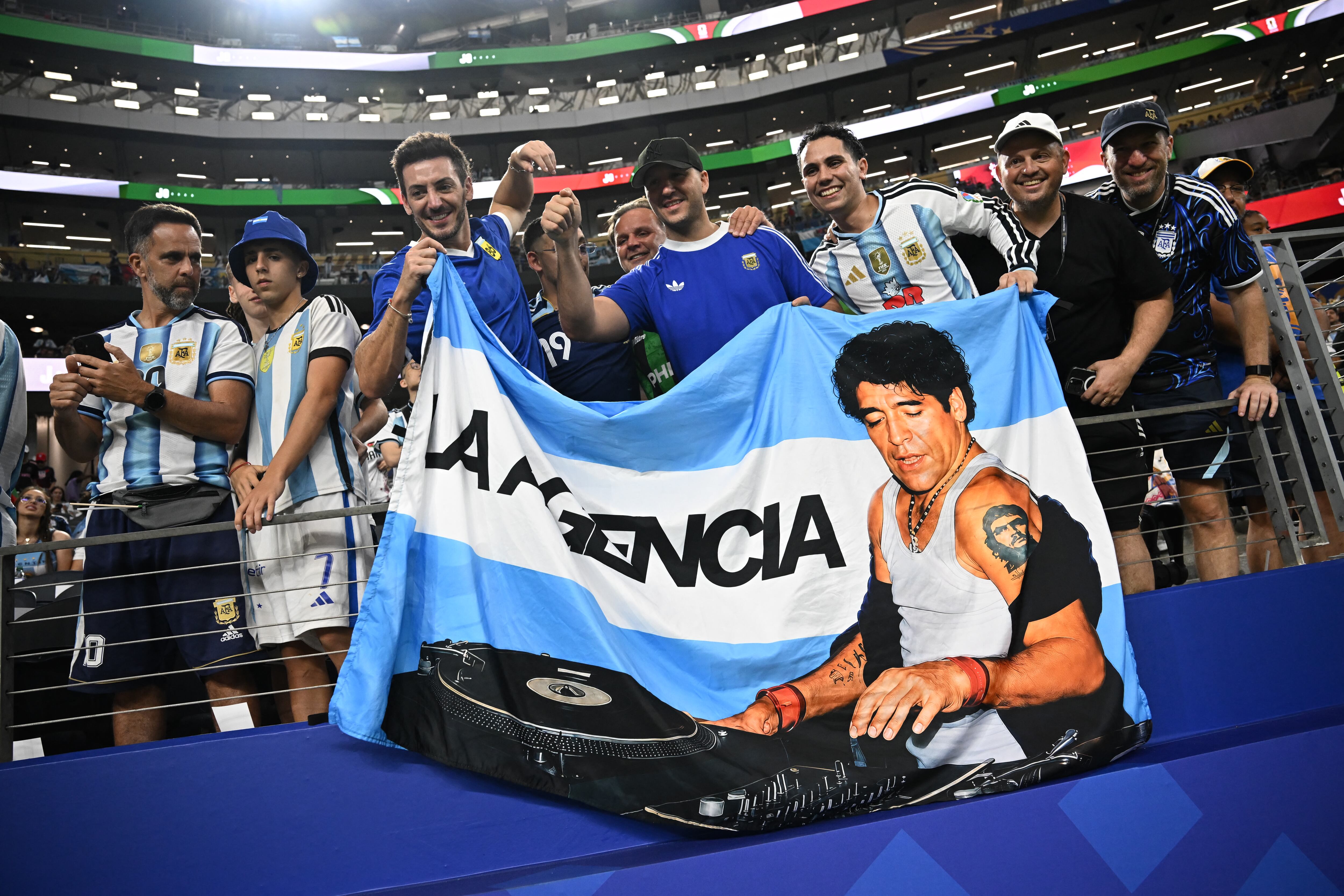Estos aficionados de Argentina muestran la imagen de Diego Maradona antes de un partido de primera fase del Mundial, en el Estadio de Dallas.