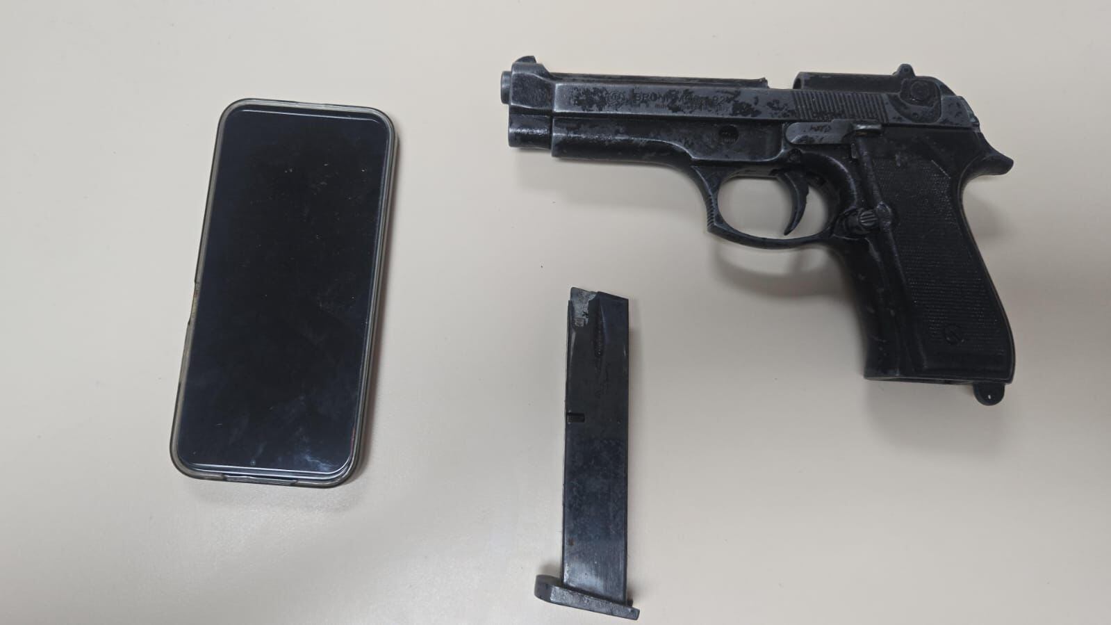 Un celular y un arma de fuego.