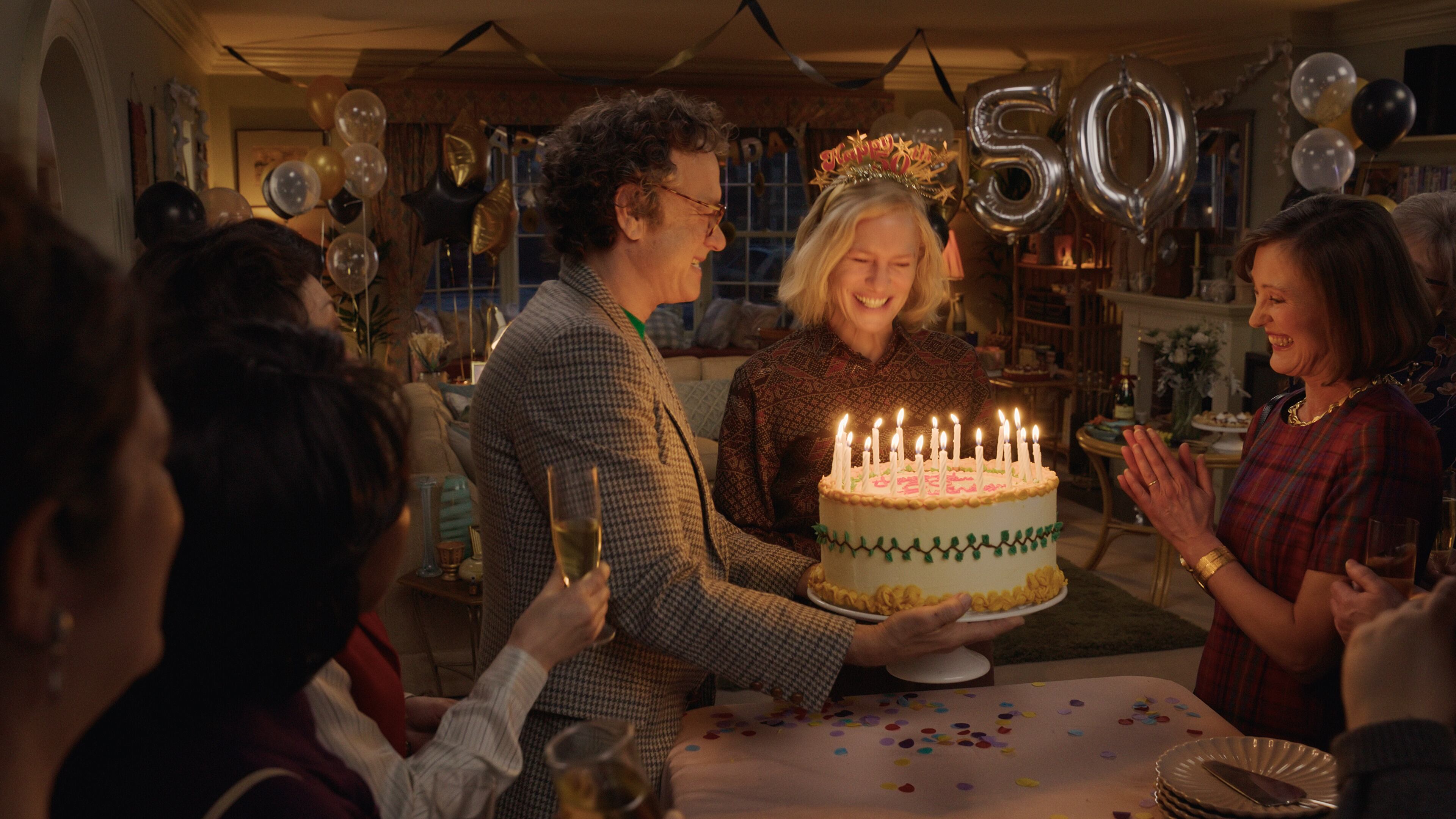 Escena de cumpleaños en la película "Here" con personajes rodeados de decoraciones festivas y un pastel.