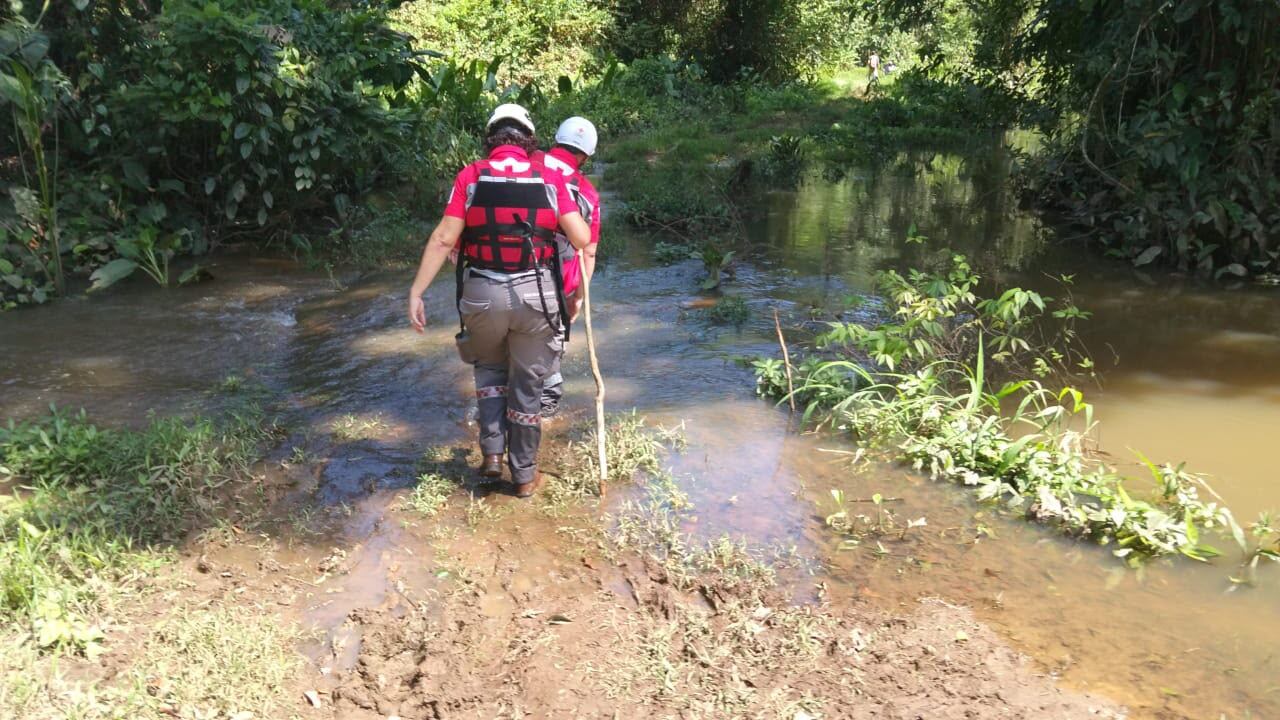 en la imagen miembros de la Cruz Roja buscan dos personas desaparecidas en río de Limón