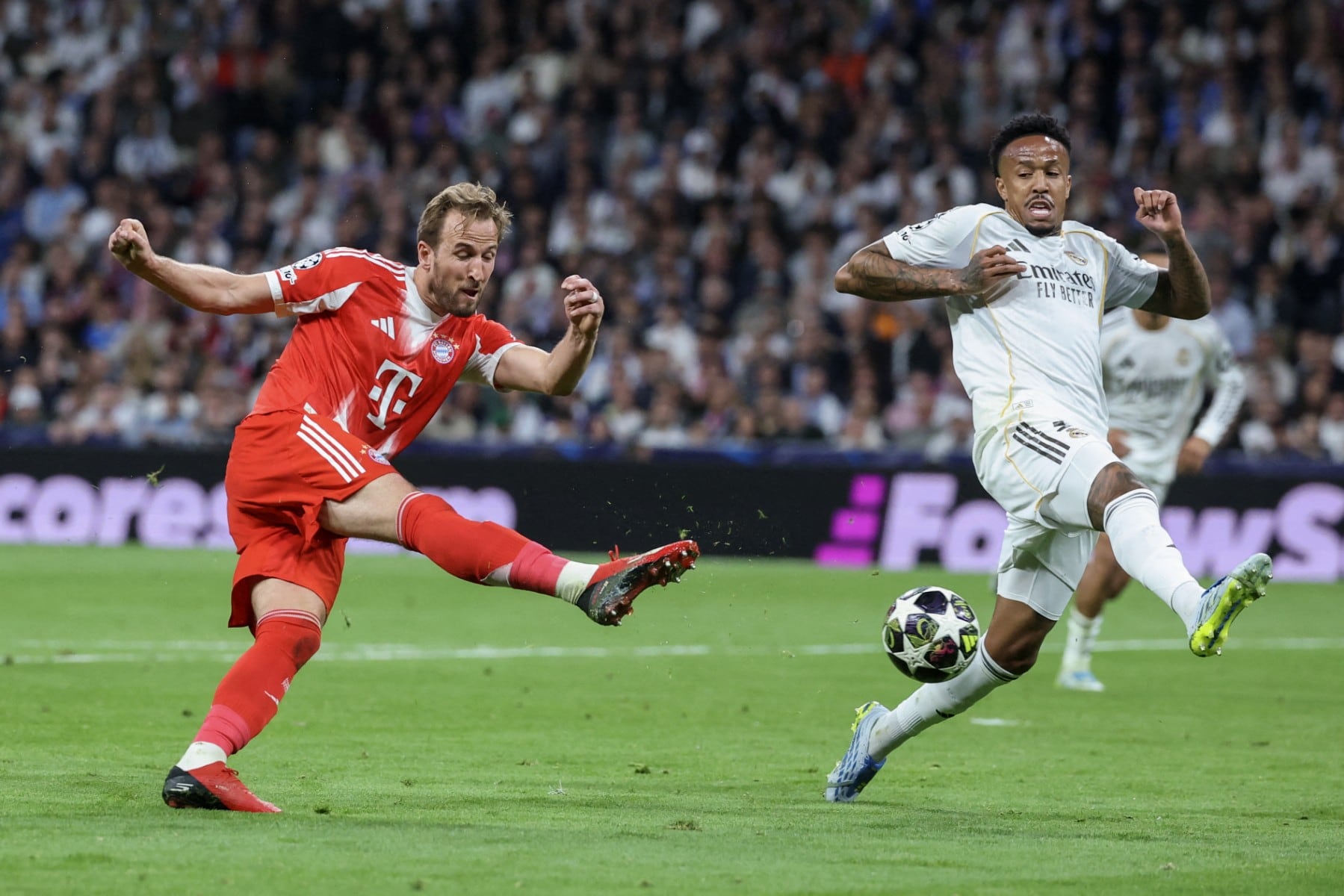 Bayern Munich's English forward #09 Harry Kane (L) shoots challenged by Real Madrid's Brazilian defender #03 Eder Militao during the UEFA Champions League quarter final first leg football match between Real Madrid CF and FC Bayern Munich at Santiago Bernabeu Stadium in Madrid on April 7, 2026. (Photo by Pierre-Philippe MARCOU / AFP)