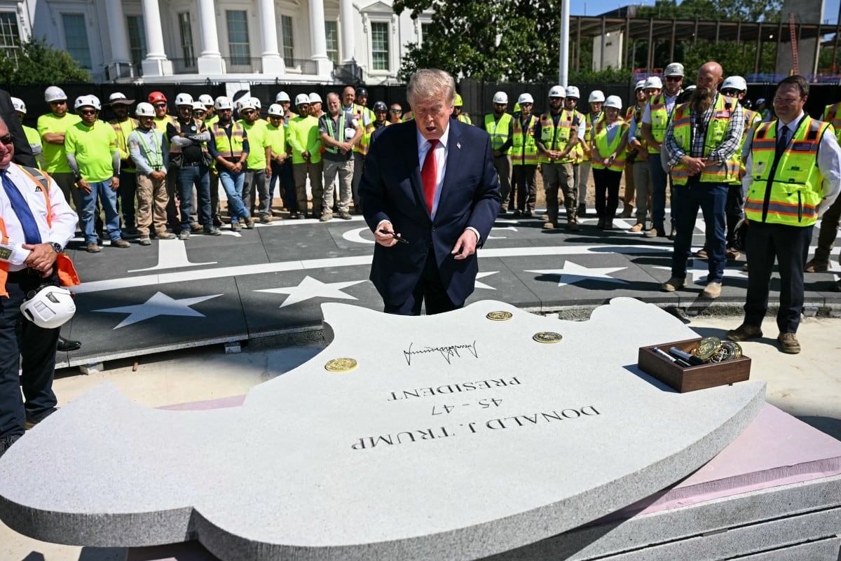 El presidente de Estados Unidos, Donald Trump, firma una piedra en el sitio de construcción de un helipuerto en el jardín sur de la Casa Blanca, en Washington D. C., el 19 de agosto de 2026.