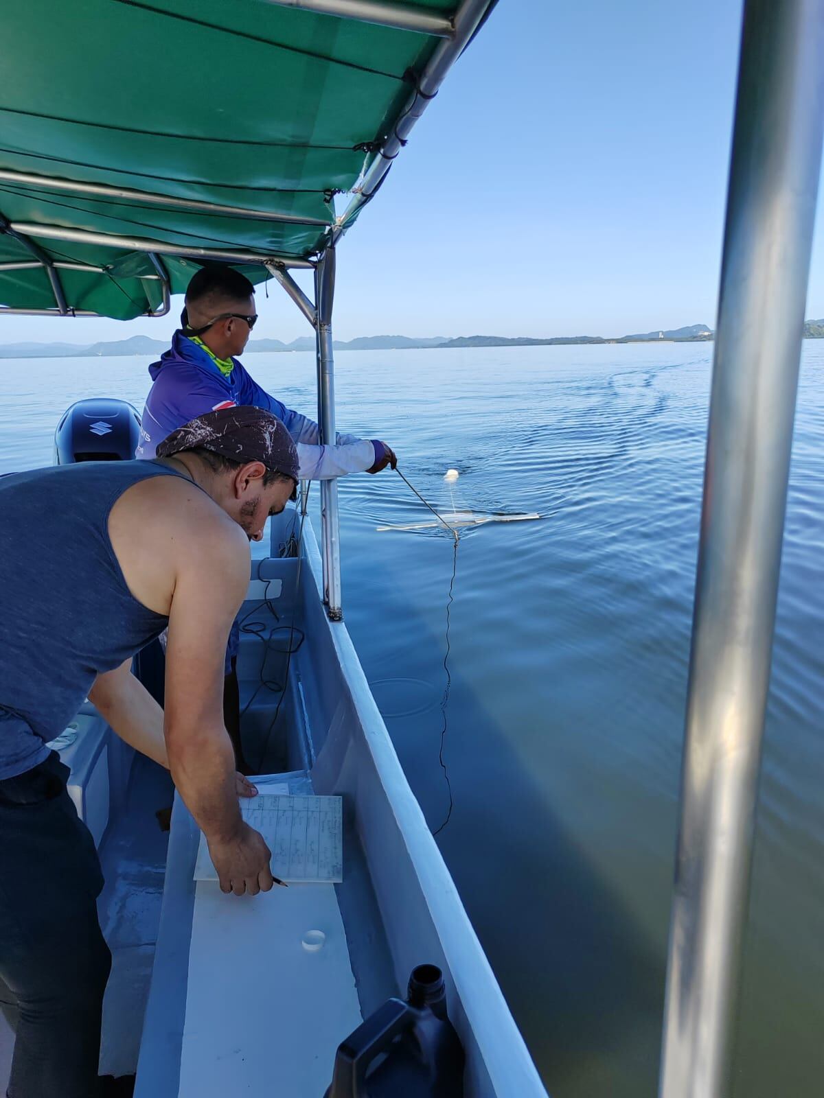 Científicos en una lancha mientras buscan microplásticos en el agua.