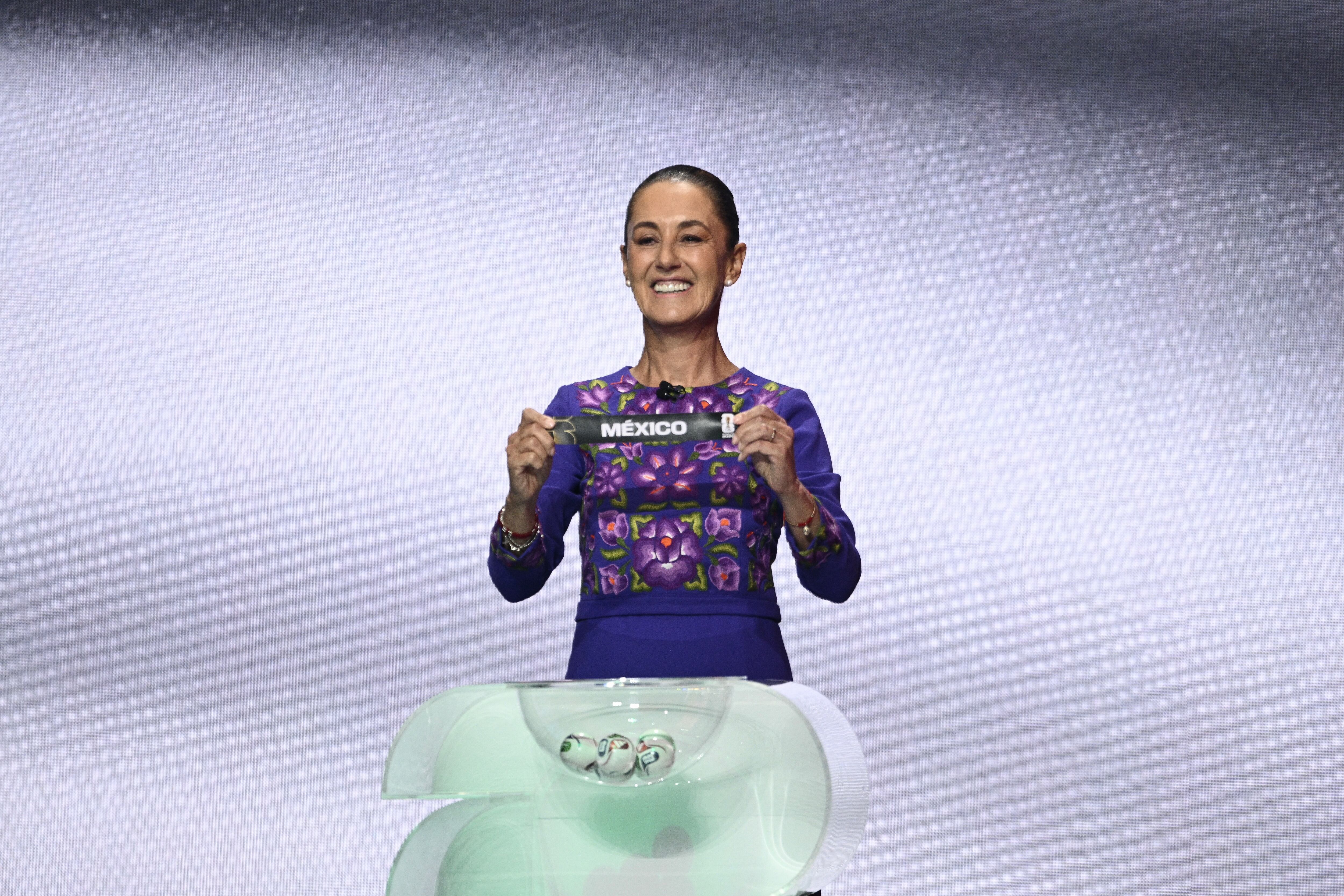 La presidenta de México Claudia Sheinbaum muestra la tarjeta con el nombre de su país durante el sorteo del Mundial 2026. Los mexicanos disputarán la inauguración.