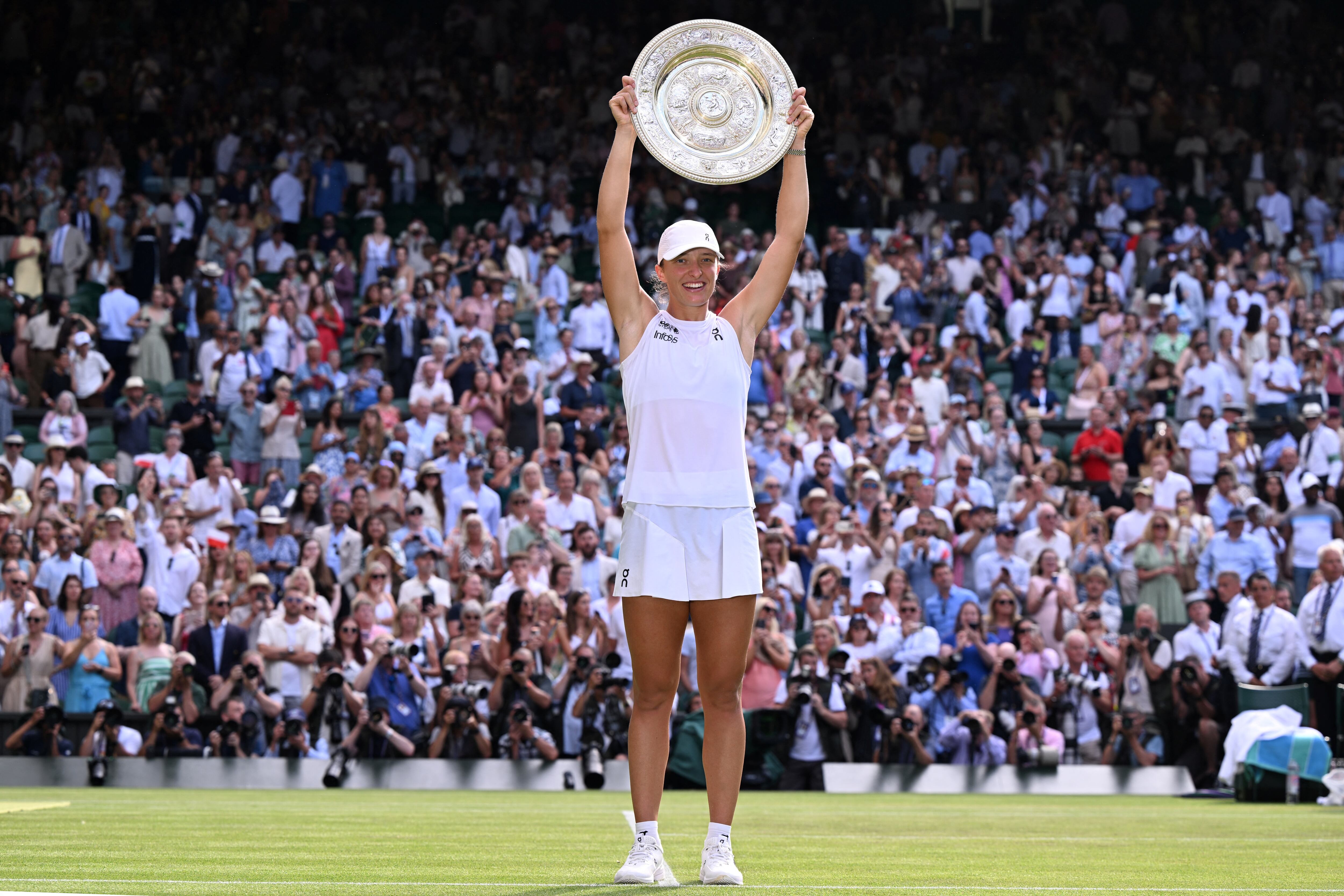 La polaca Iga Swiatek celebra con el trofeo de ganadora luego de imponerse en la edición 2025 de Wimbledon.