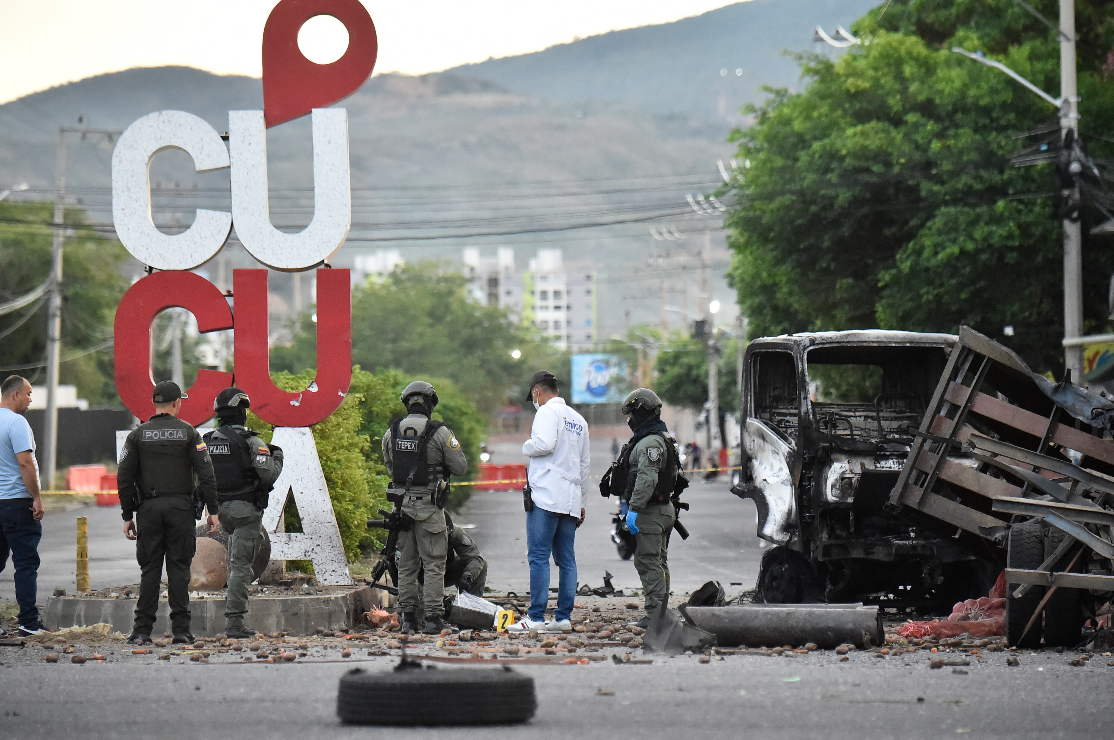 Investigadores forenses y policías revisan los restos tras la explosión de un carro bomba cerca de una estación policial en Cúcuta, Colombia. El ataque dejó al menos 11 personas heridas.