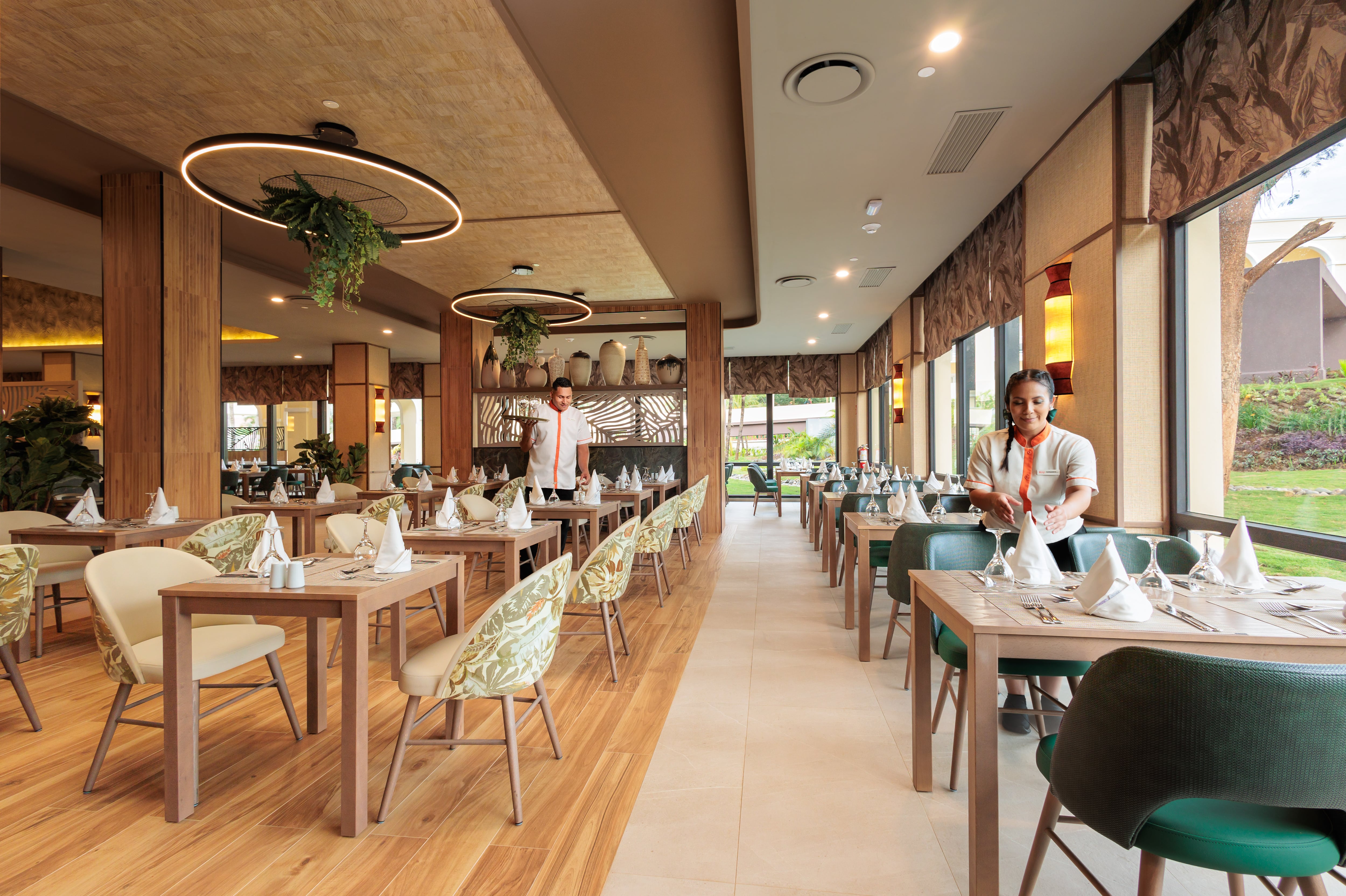 Vista del restaurante estilo buffet recién inaugurado en el hotel Riu Guanacaste, con mesas preparadas y personal ajustando detalles para los comensales.