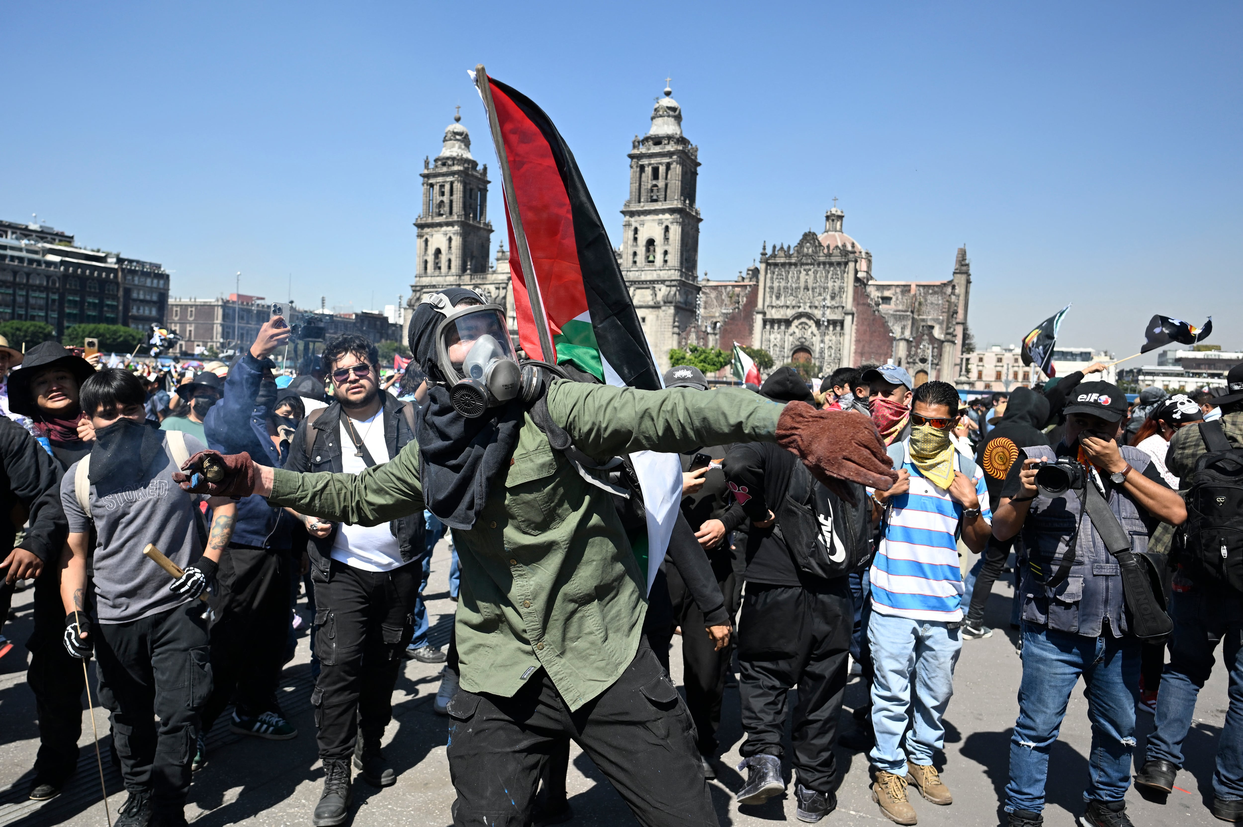 En la imagen, un hombre lanza una piedra durante una manifestación contra el gobierno de la presidenta mexicana Claudia Sheinbaum en la Plaza del Zócalo de la Ciudad de México el 15 de noviembre de 2025.
