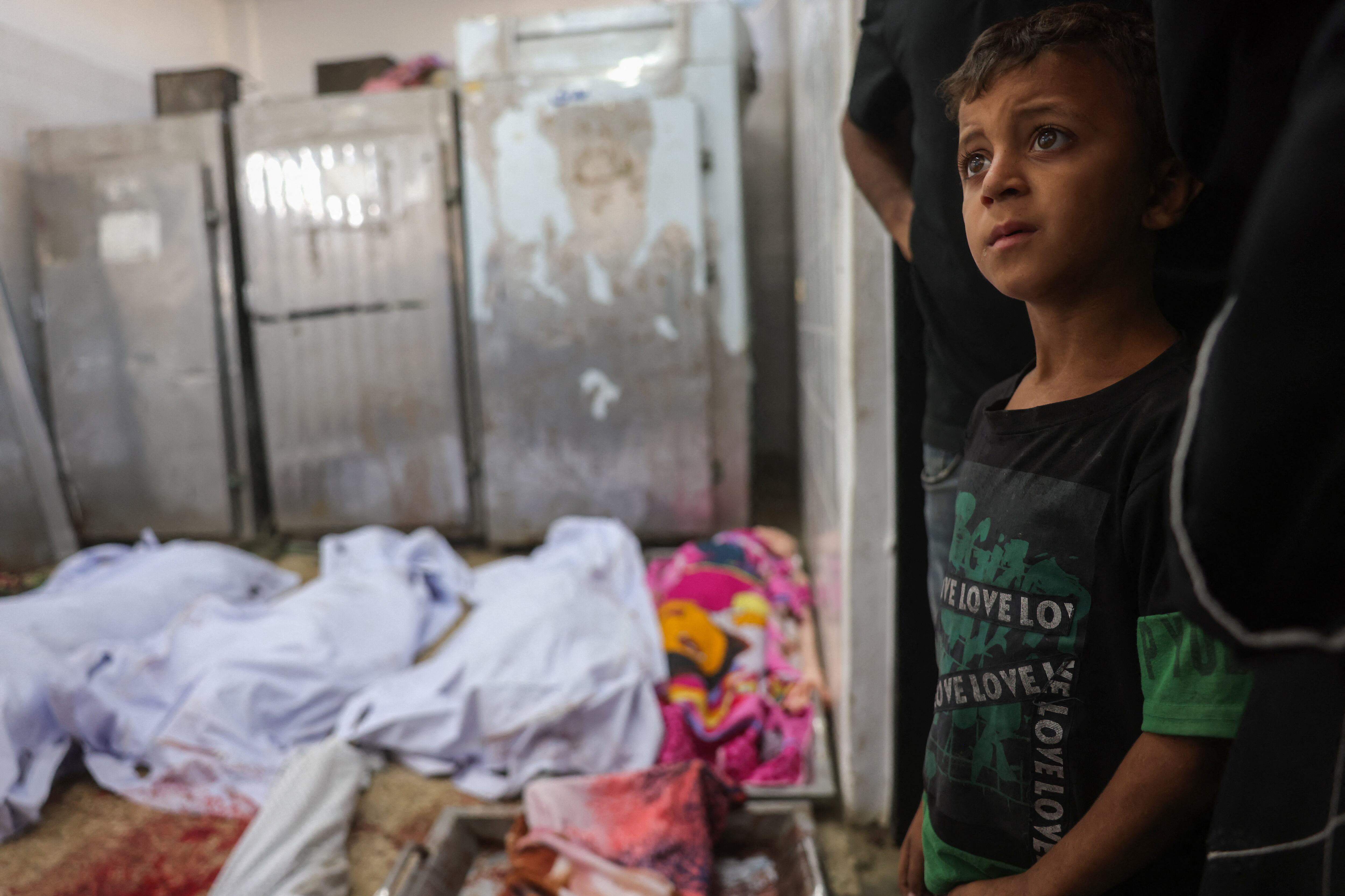 Un niño palestino se encuentra junto a los cadáveres de las víctimas de los ataques israelíes en Deir al-Balah, en la morgue del Hospital de los Mártires de Al-Aqsa, en el centro de la Franja de Gaza, el 2 de octubre de 2025.