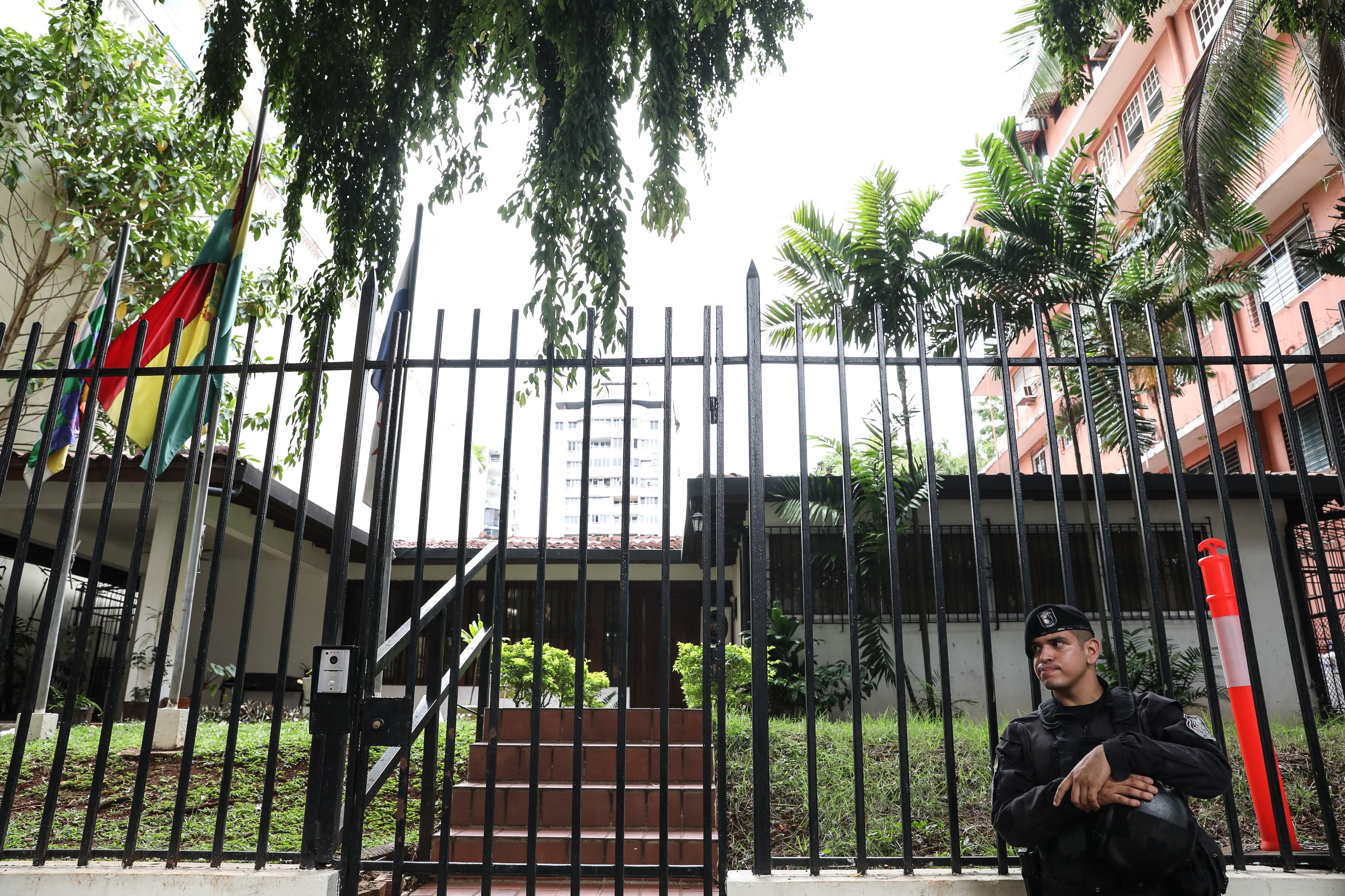 A police officer stands guard outside the Bolivian embassy in Panama City on May 21, 2025. Top union leader Saul Mendez, involved in protests against Panama's President Jose Raul Mulino, scaled the fence of the Bolivian embassy to seek asylum on Wednesday after a colleague was arrested, authorities said. (Photo by Aris MARTINEZ / AFP)