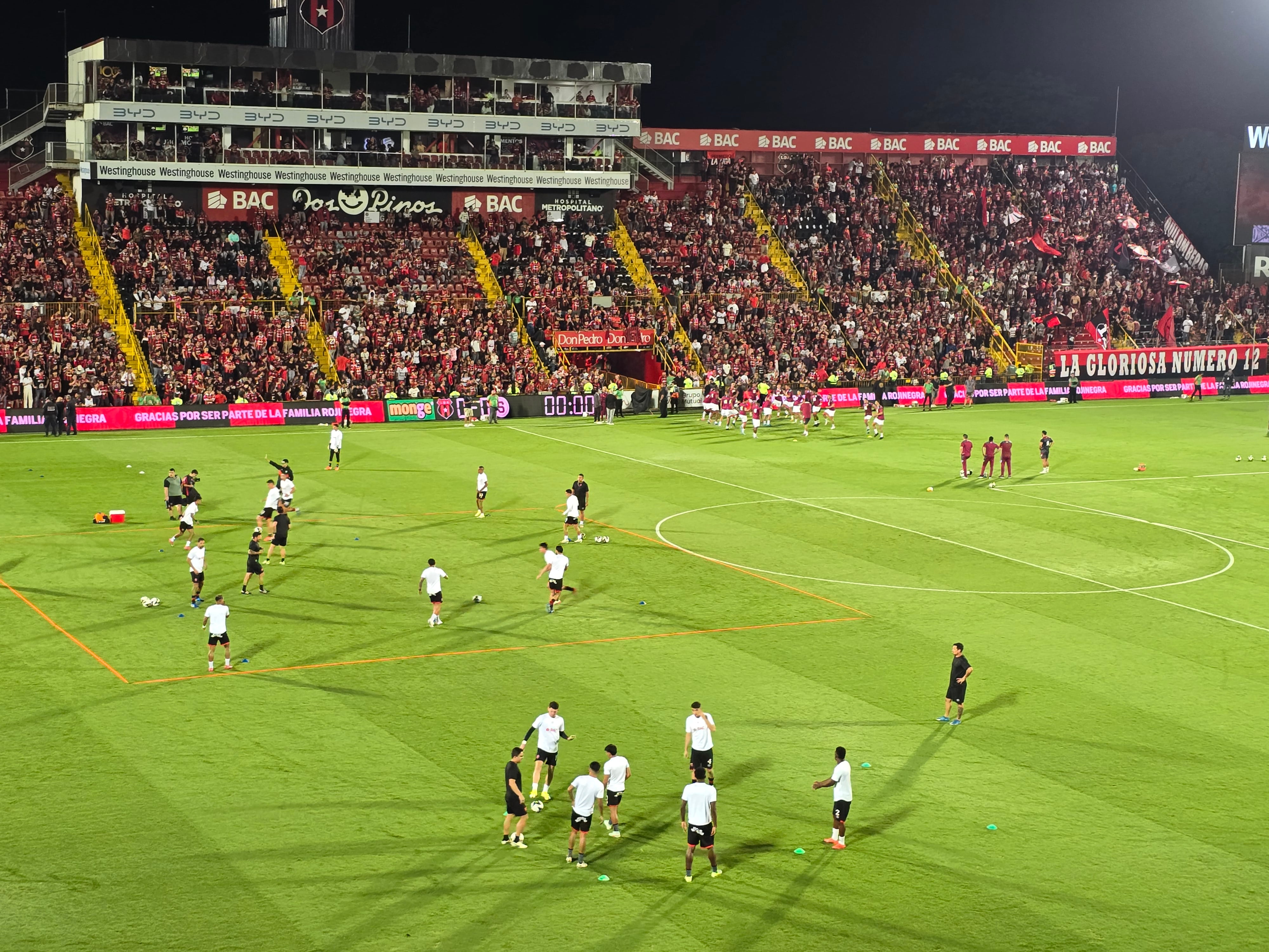 Liga Deportiva Alajuelense y Saprissa calientan en la gramilla híbrida del Estadio Alejandro Morera Soto.