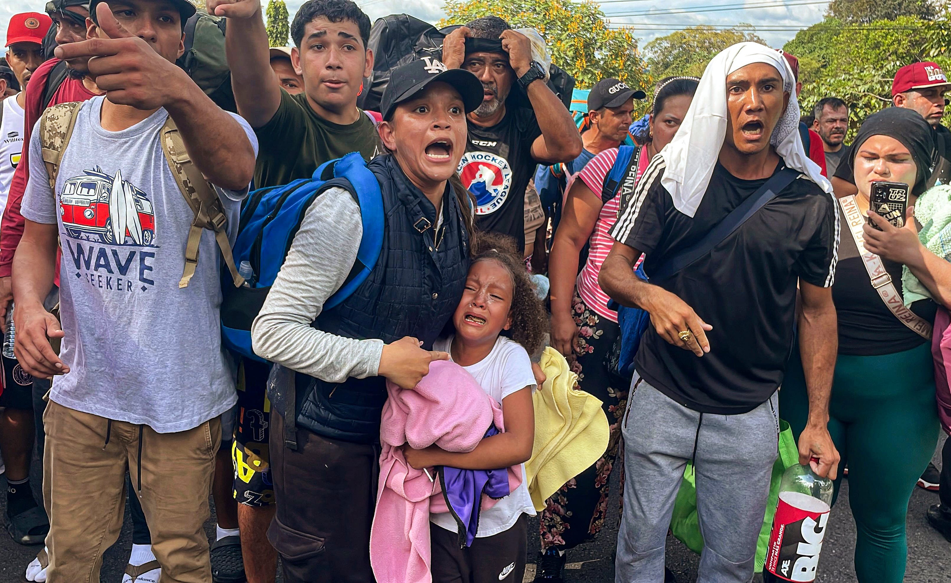 Migrants argue with Panamanian National Border Service members as they try to cross the border between Panama and Costa Rica while trying to return to Venezuela, at Paso Canoas between Panama and Costa Rica border on February 11, 2025. Dozens of Venezuelan migrants crossed the border from Costa Rica into Panama on Tuesday in a small caravan as they gave up the journey to the United States, overwhelmed by the grueling journey and fearful of Donald Trump's harsh anti-immigrant policies. (Photo by PAUL MONTENEGRO / AFP)