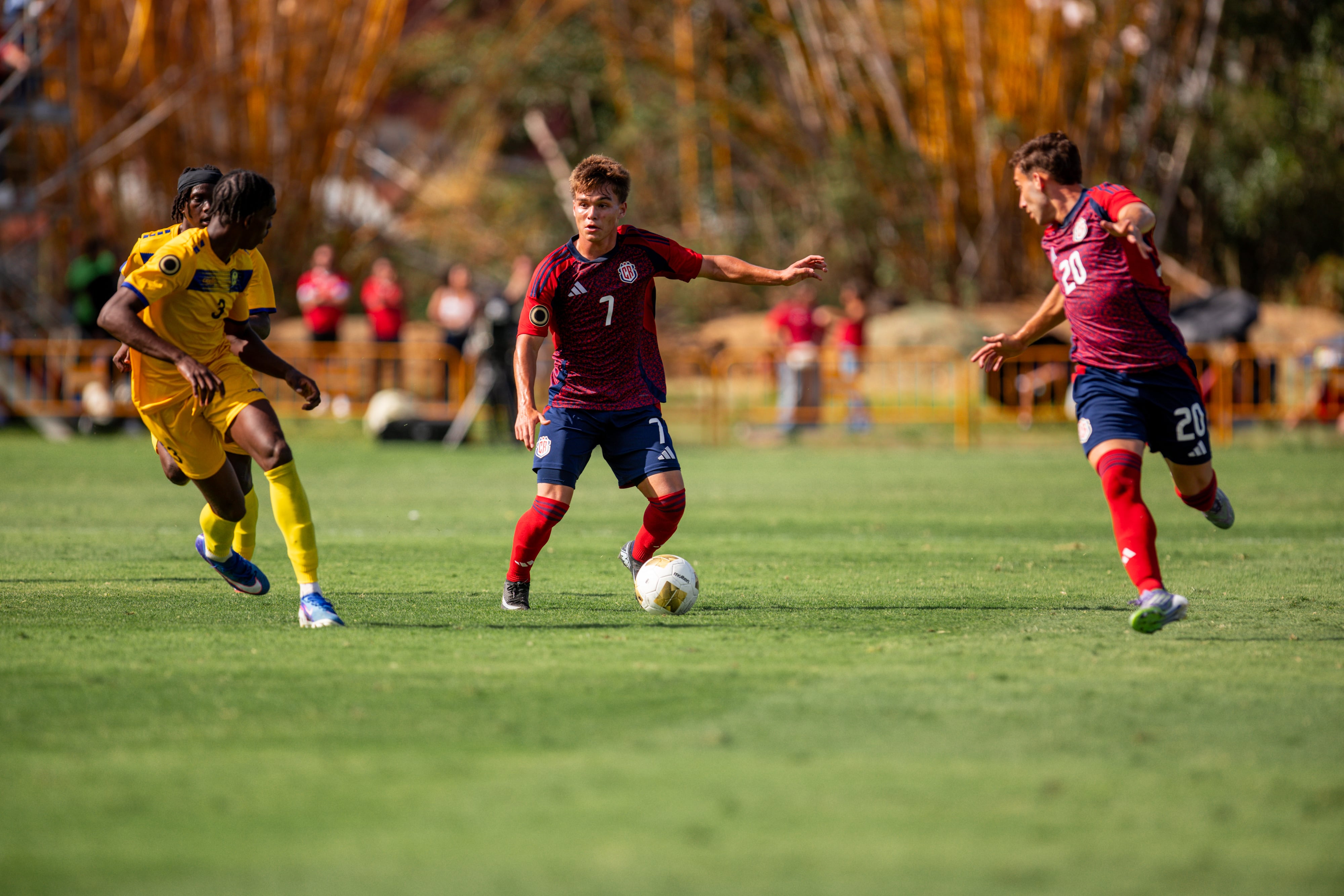 Yamil Leal (7) transporta el balón y Dylan Oviedo sigue la jugada con atención, esperando un pase, en el partido entre la Selección Sub-20 de Costa Rica y Barbados.
