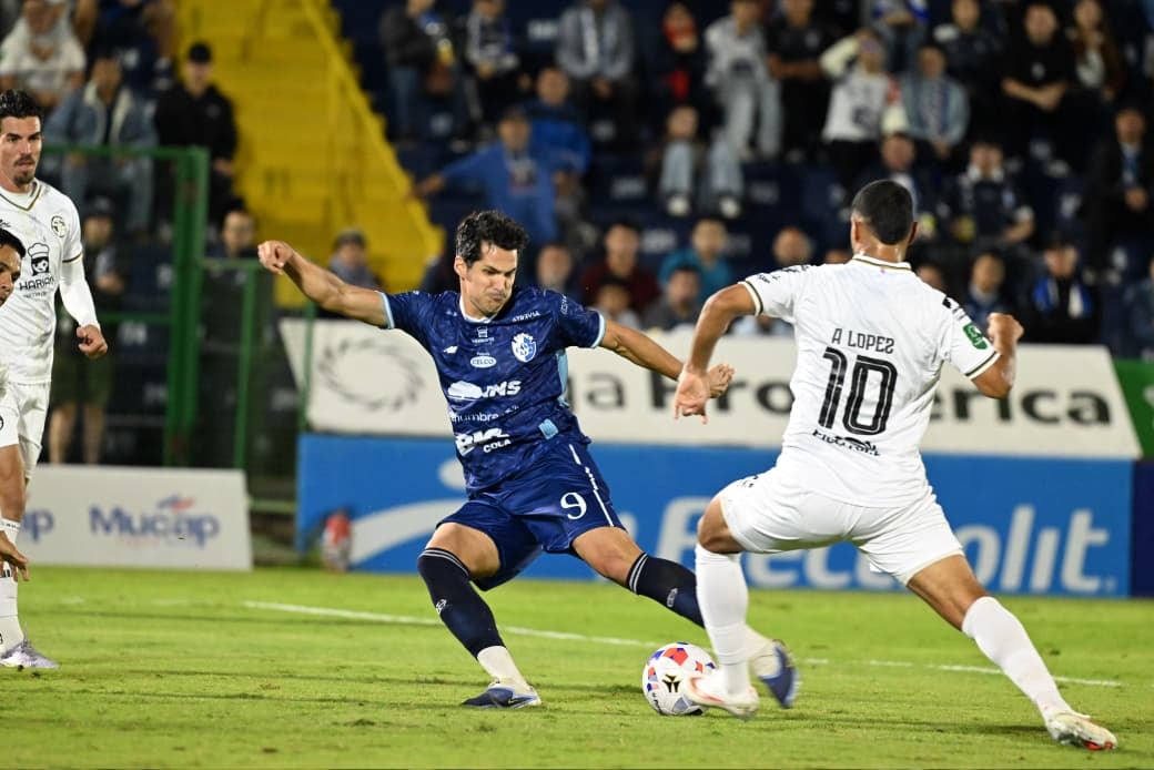 José González sacó un remate de pierna izquierda para anotar ante Sporting, esto ante la mirada de Alex López.
