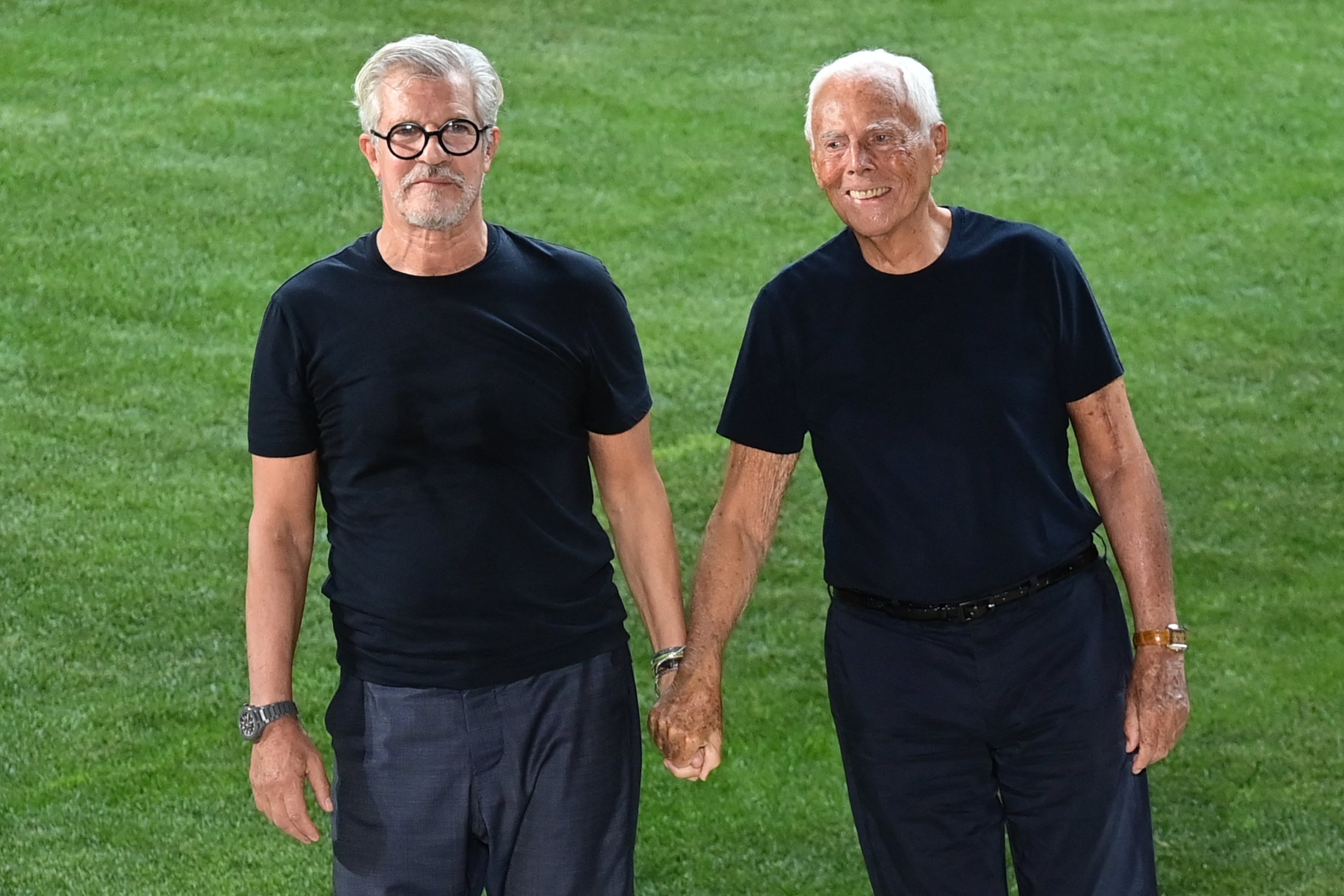 El diseñador de moda italiano Giorgio Armani (derecha) y su colaborador histórico Leo Dell'Orco agradecen los aplausos tras la presentación de la colección de moda masculina Primavera-Verano 2022 de Giorgio Armani, el 21 de junio de 2021 durante la Semana de la Moda de Milán. (Foto: MIGUEL MEDINA / AFP)