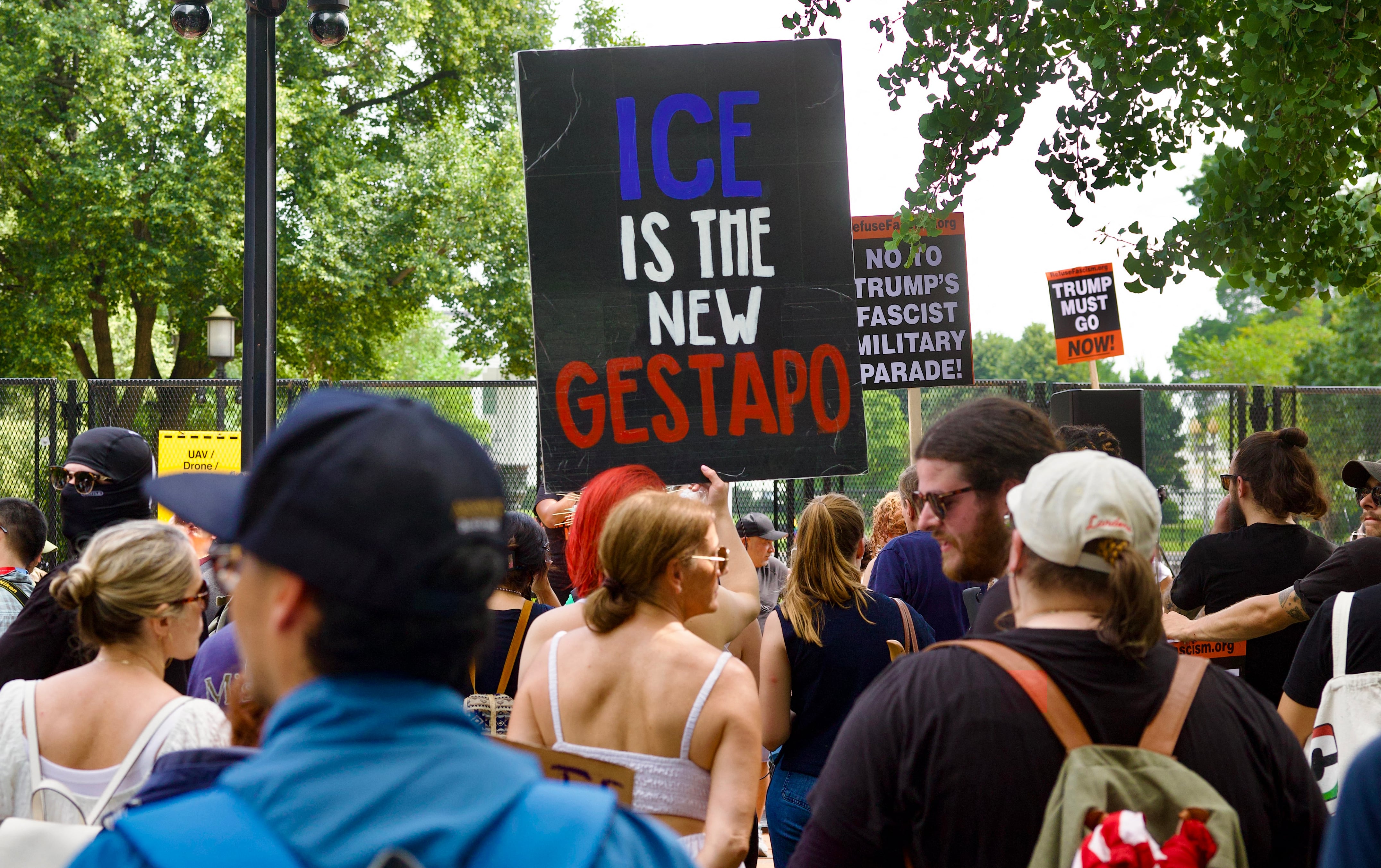 Manifestantes sostienen un cartel que dice "ICE es la nueva Gestapo" durante la protesta "No Kings" en Lafayette Square, Washington D. C., el 14 de junio de 2025, día del desfile militar del presidente Trump. La manifestación responde al desfile militar conmemorativo del 250.º aniversario del Ejército de Estados Unidos, que también coincidió con el cumpleaños número 79 de Trump. El movimiento "No Kings" surgió como reacción y promete realizar protestas en más de 2.000 lugares del país, incluida una gran marcha en Los Ángeles, donde los organizadores aseguran que se presentará un "globo de Trump de seis metros con pañal". (Foto: Amid Farahi / AFP)