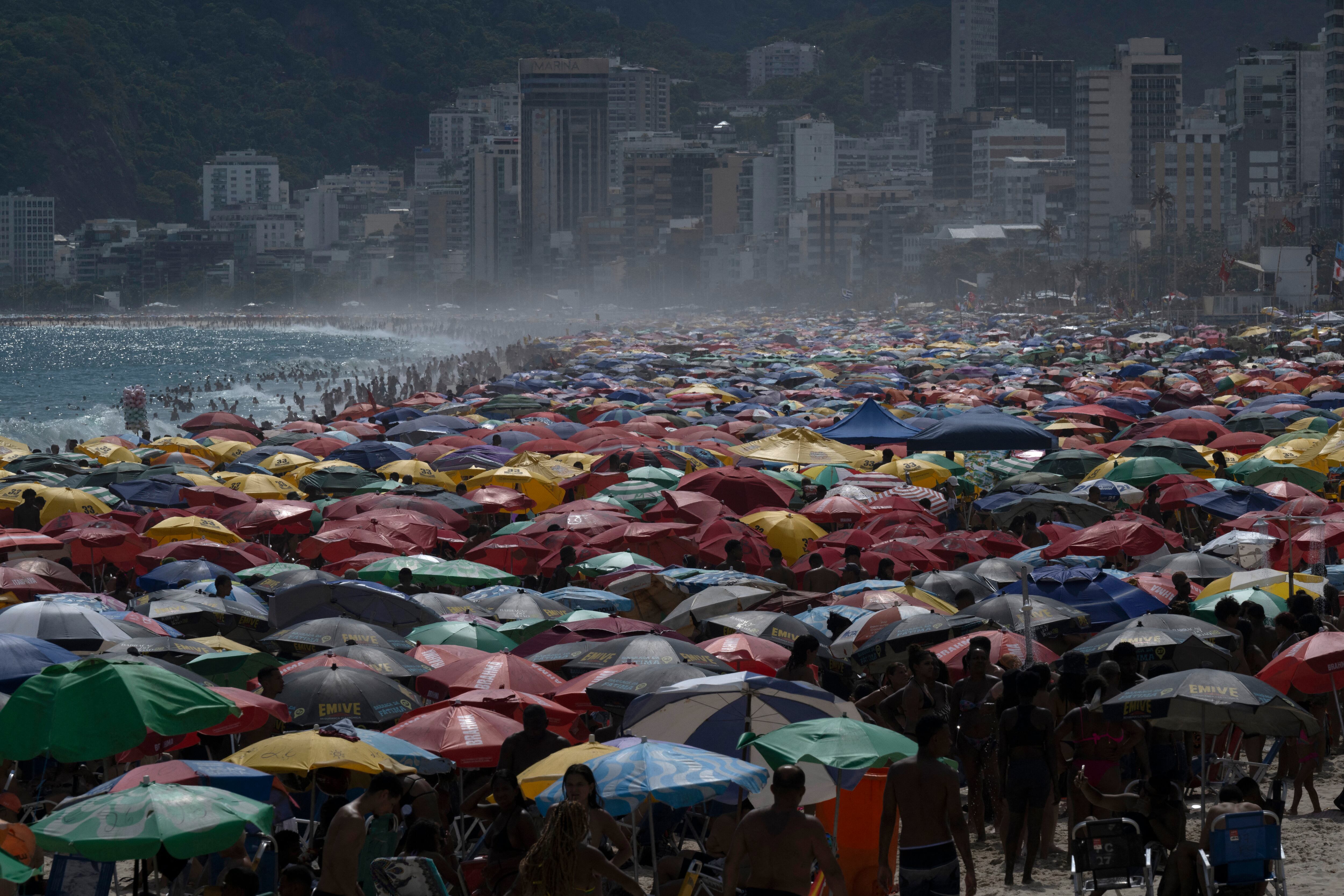View of people enjoying Ipanema beach in Rio de Janeiro, Brazil, on February 9, 2025. (Photo by Pablo PORCIUNCULA / AFP)