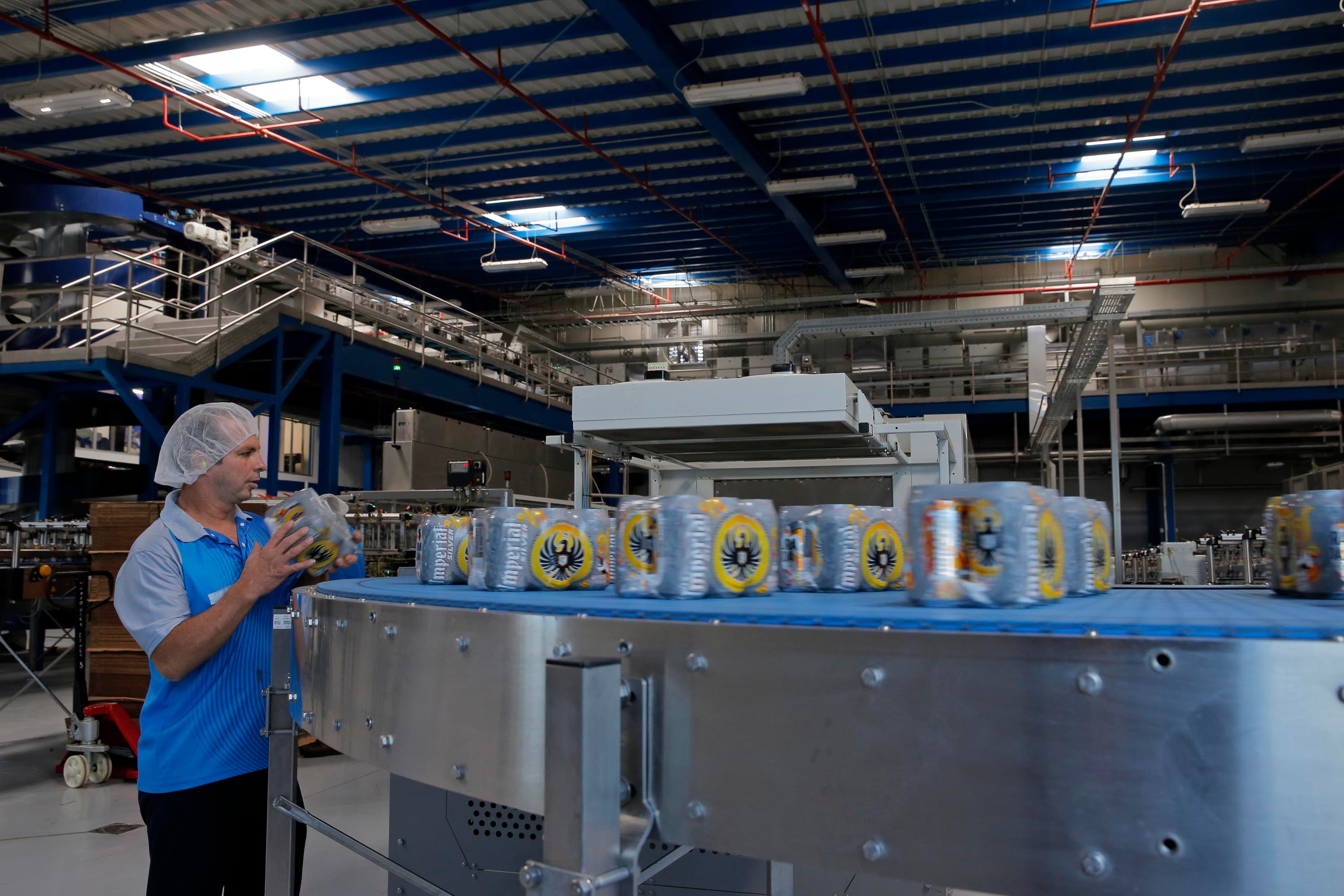 Empleado revisando empaques de cerveza Imperial en una planta de producción de Florida Ice and Farm, primera en el ranking ESG 2024 en Costa Rica.