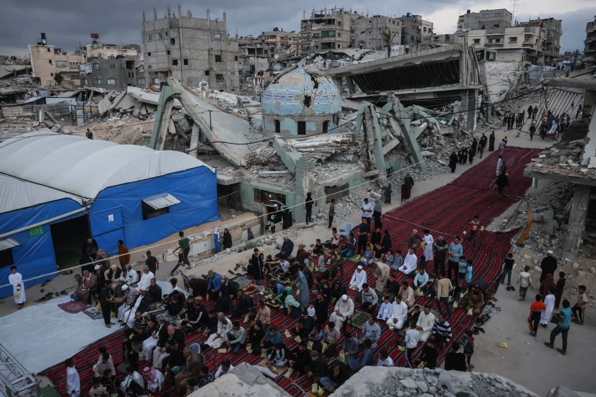 “Palestinos se reúnen en una calle gravemente dañada para realizar las oraciones matutinas que marcan el inicio del Eid al-Adha, la Fiesta del Sacrificio, en Jan Yunis, en el sur de la Franja de Gaza, el 27 de mayo de 2026.