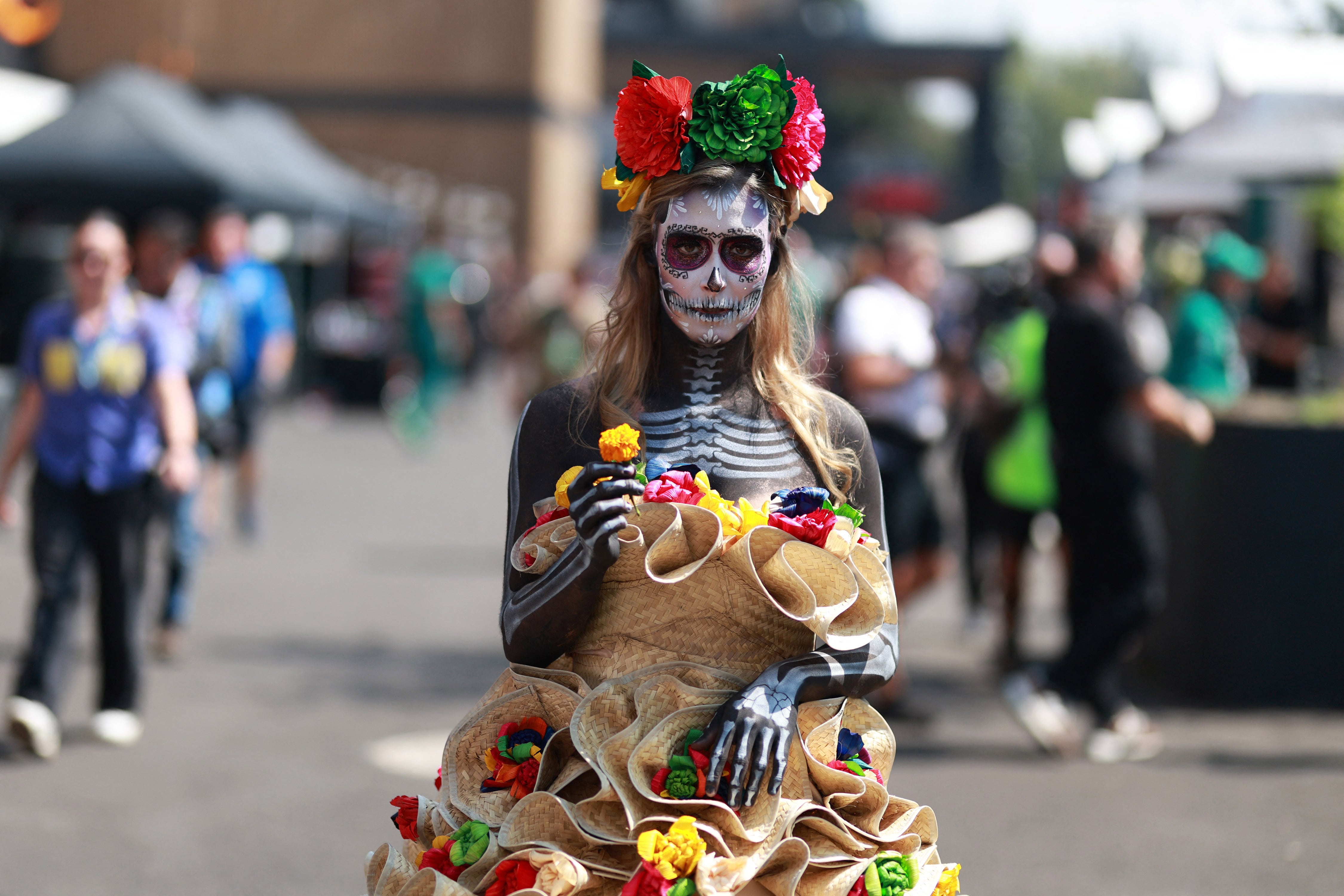 Una mujer vestida como una catrina camina por el paddock del Gran Premio de México, en el Autódromo Hermanos Rodríguez de la capital azteca.