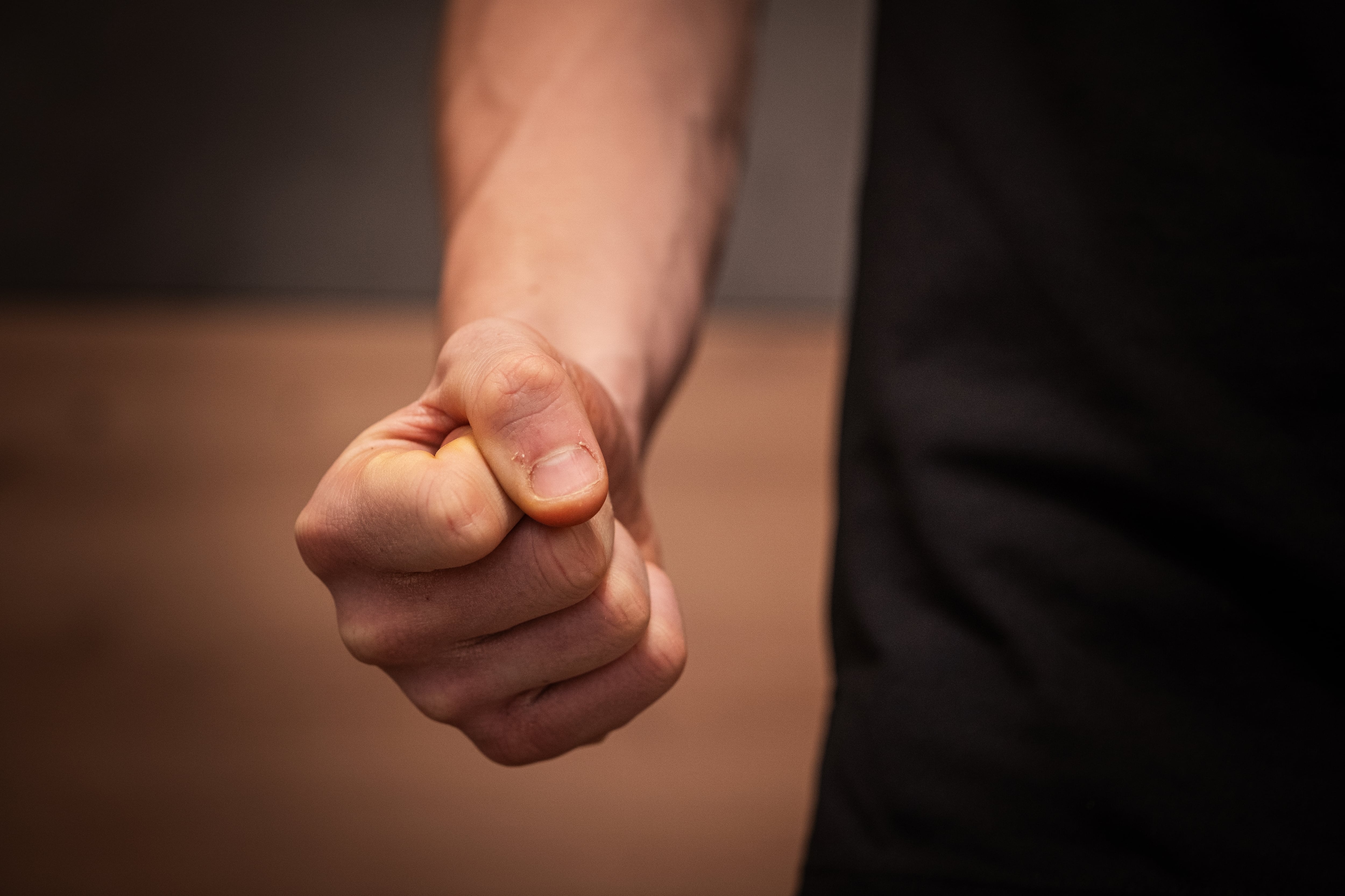 Primer plano de un puño cerrado, puño de hombre, puño en señal de amenaza, intención de golpe, de golpear