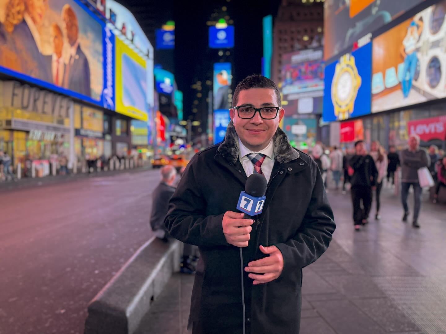 El periodista Elías Alvarado sosteniendo un micrófono de Teletica en Times Square, Nueva York.