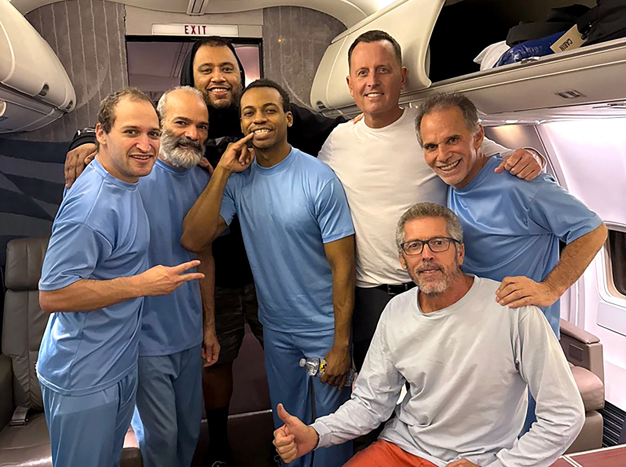 Enviado especial del presidente estadounidense Donald Trump, Richard Grenell (3.º por la derecha), posando a bordo de un avión junto a seis ciudadanos estadounidenses liberados de detención en Venezuela.