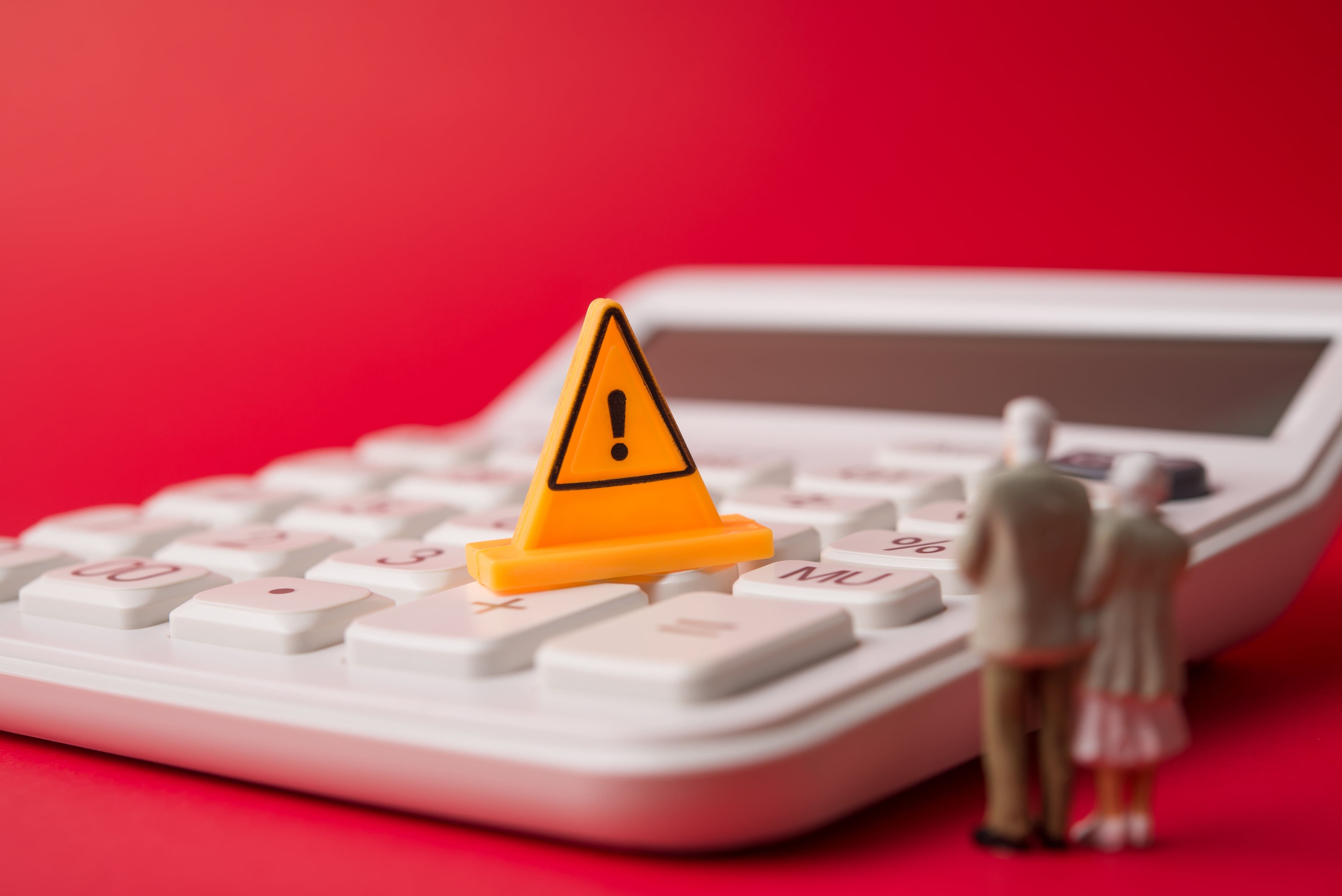 Señal de advertencia sobre una calculadora con figuras de adultos mayores, en alusión al aumento del costo de pensiones del régimen RTR y la presión sobre el Presupuesto Nacional en Costa Rica