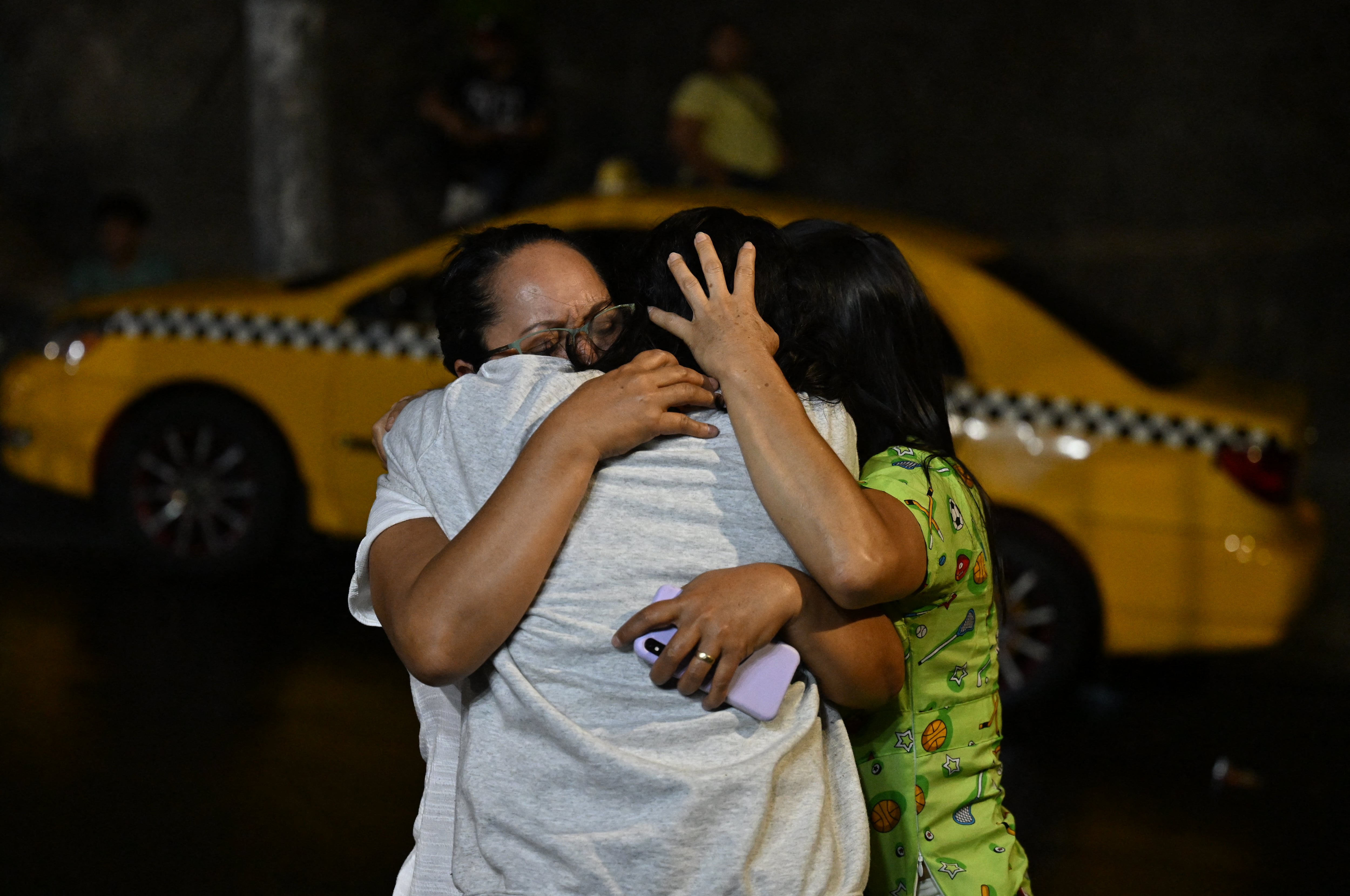 A Salvadoran migrant deported from the United States is received by family members as she leaves the Center for Attention to Returned Migrants in San Salvador on February 26, 2025. (Photo by Marvin RECINOS / AFP)