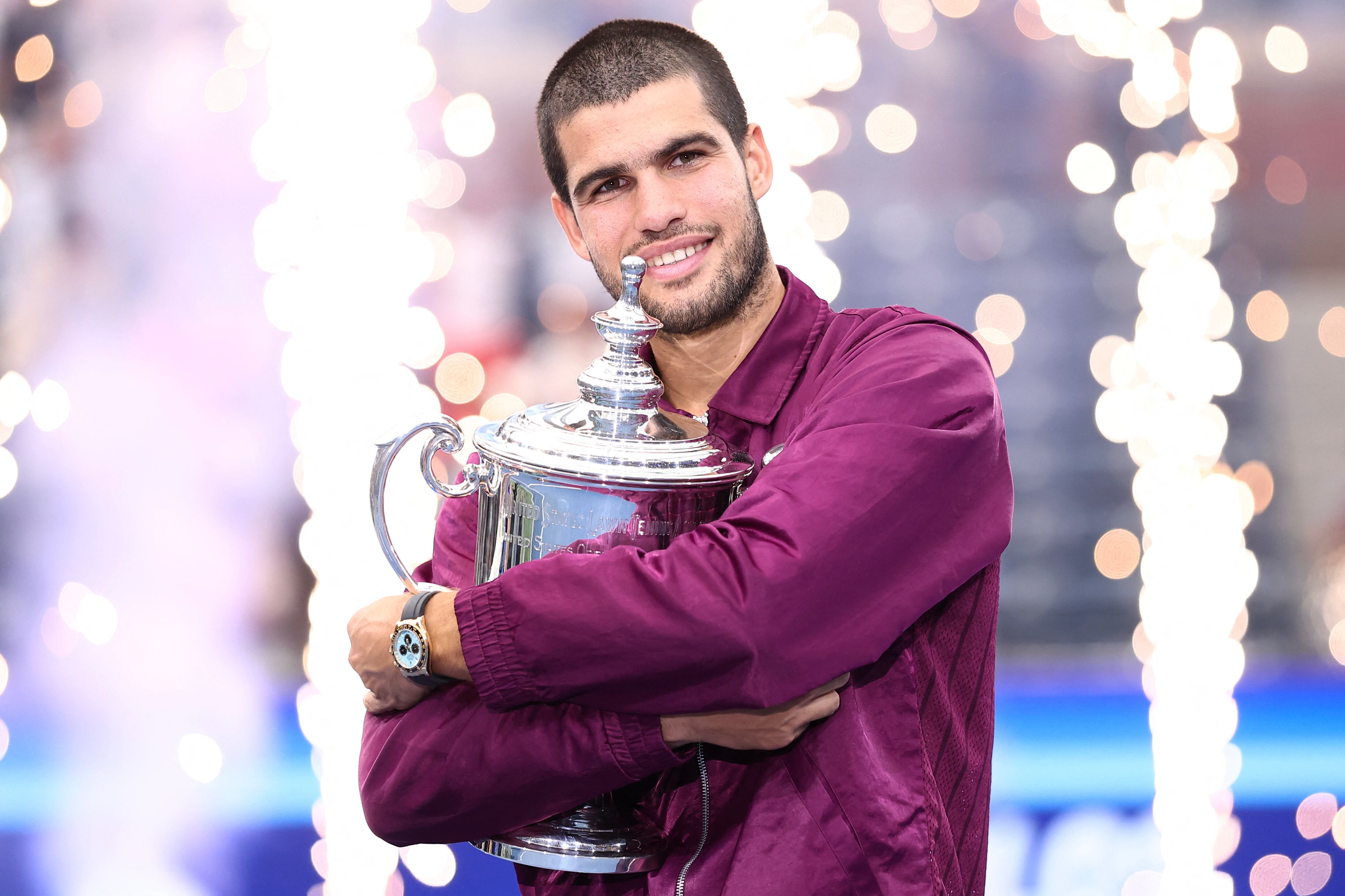 El tenista español Carlos Alcaraz abraza el trofeo de campeón tras imponerse al italiano Jannik Sinner en la final del Abierto de Estados Unidos.