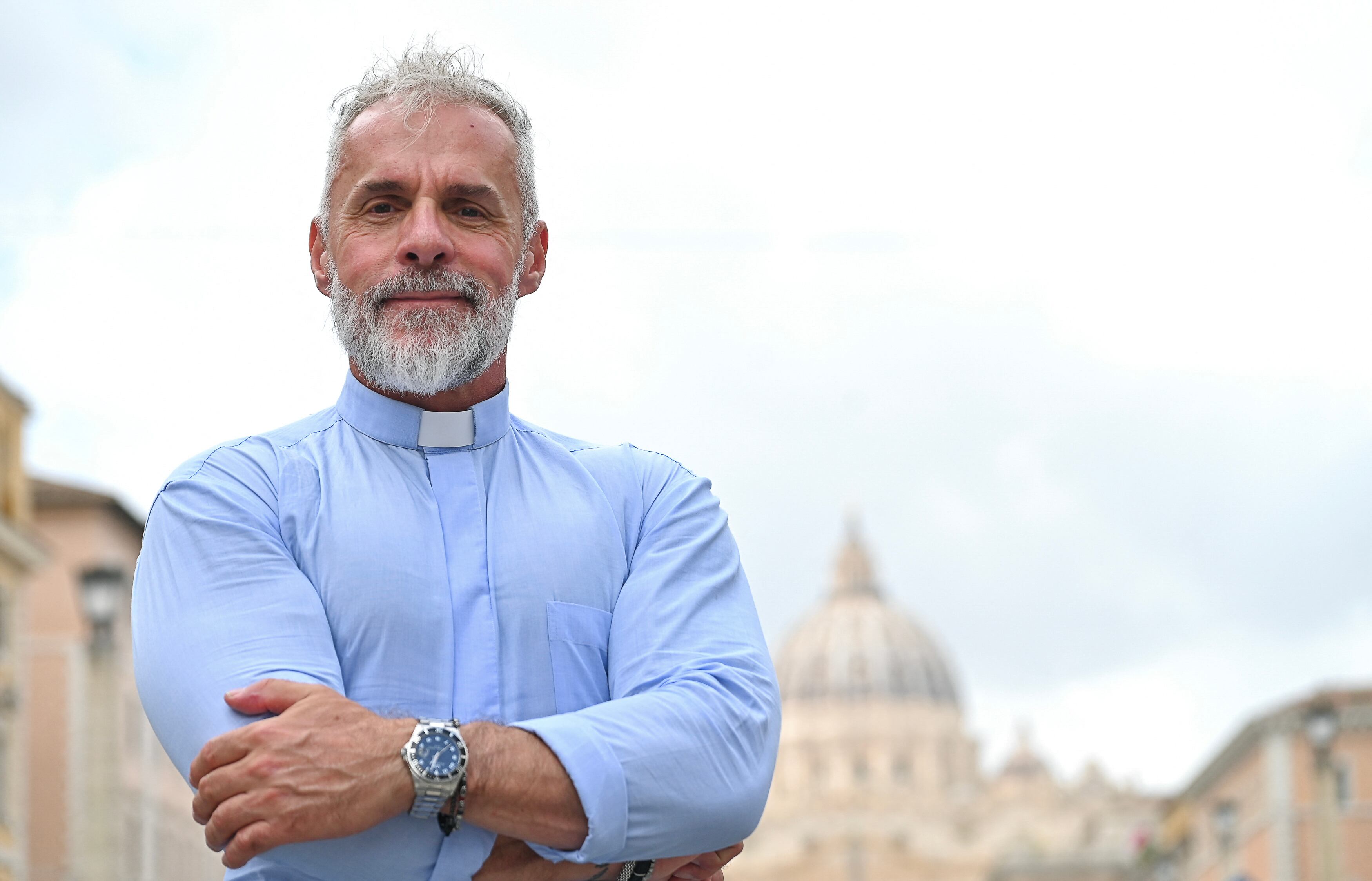 El sacerdote católico e influencer italiano en redes sociales, Giuseppe Fusari, posa cerca del Vaticano, en la calle Via della Conciliazione, con la Basílica de San Pedro al fondo, en Roma, el 28 de julio de 2025. El Vaticano los llama “misioneros digitales” y —en un hecho sin precedentes para esta institución centenaria— el papa León XIV presidió una misa dedicada a ellos en la Basílica de San Pedro, exhortándolos a crear contenido para quienes “necesitan conocer al Señor”. (Foto de Alberto PIZZOLI / AFP)