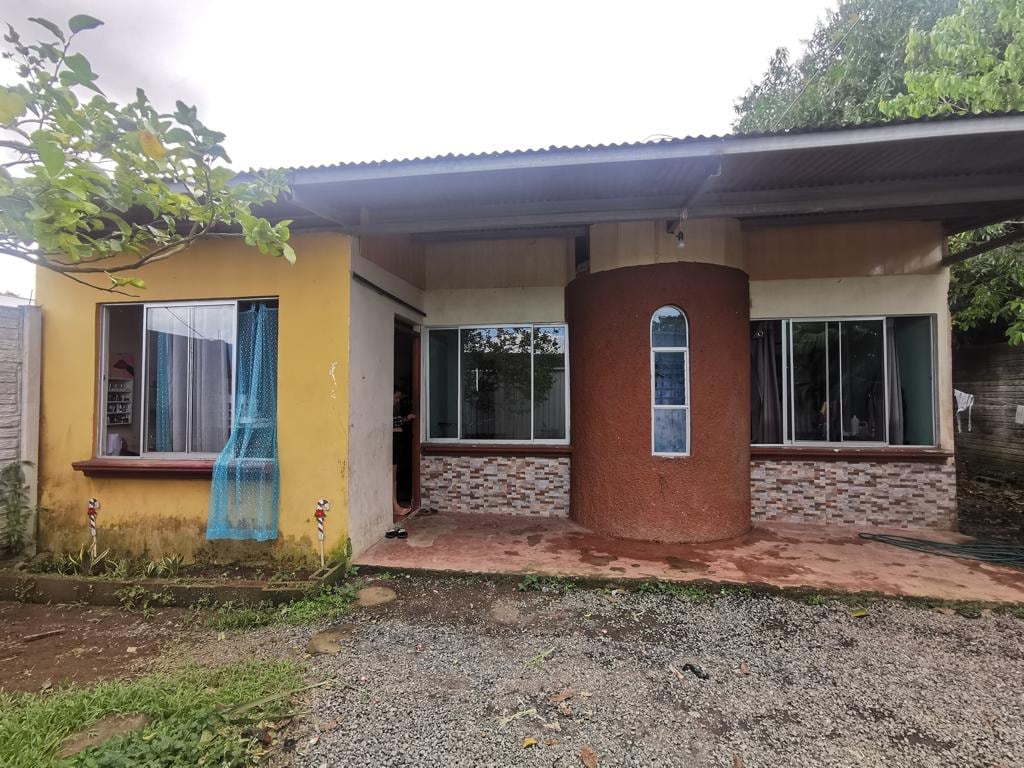 Casa en Guápiles de Pococí con 3 habitaciones y 2 baños. Tiene cochera y zona verde. Ubicada en Cascadas 1. Requiere mejoras para financiamiento.