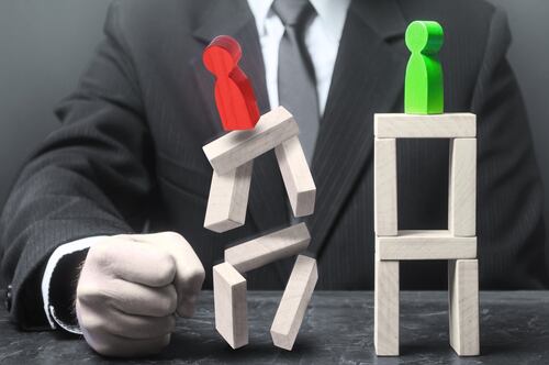 Representación simbólica del autoritarismo en la sociedad, con figuras de madera desbalanceadas y un puño derrumbando estructuras.