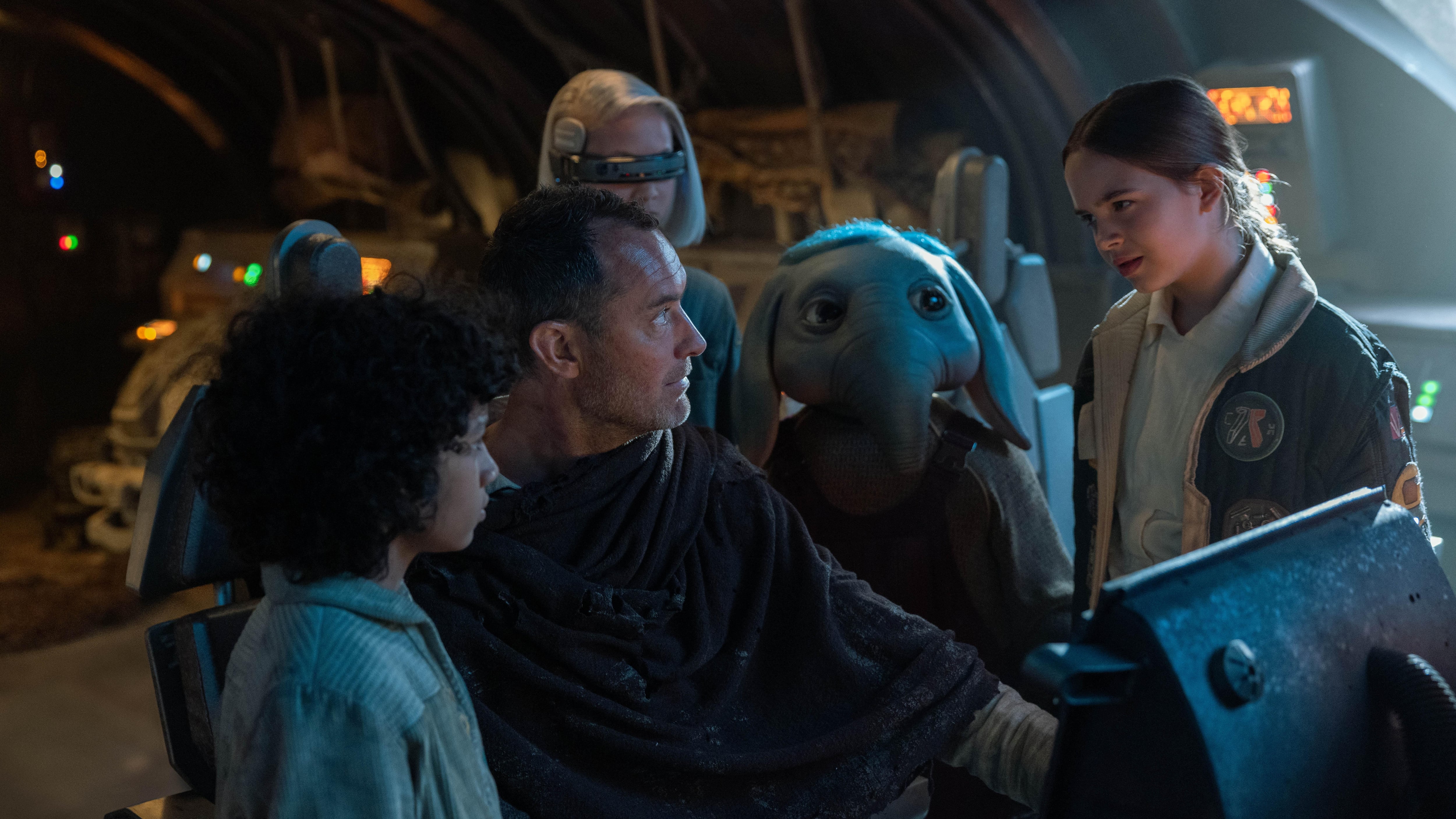 Fotograma de la serie Star Wars: Skeleton Crew, en la que Jude Law interpretando a Jod Na Nawood está rodeado del escuadro infantil que estelarizará el show.